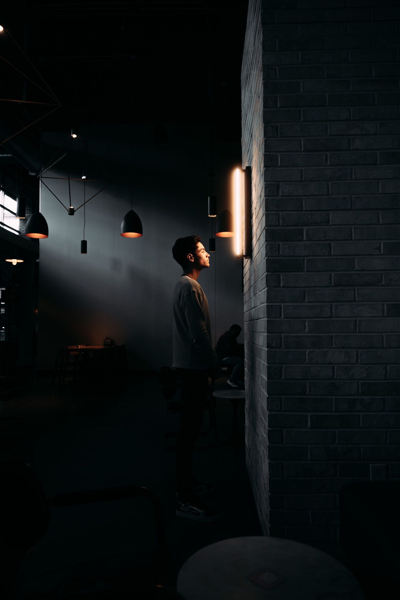 Moody architectural photos in dark space with dramatic lighting and brick walls.