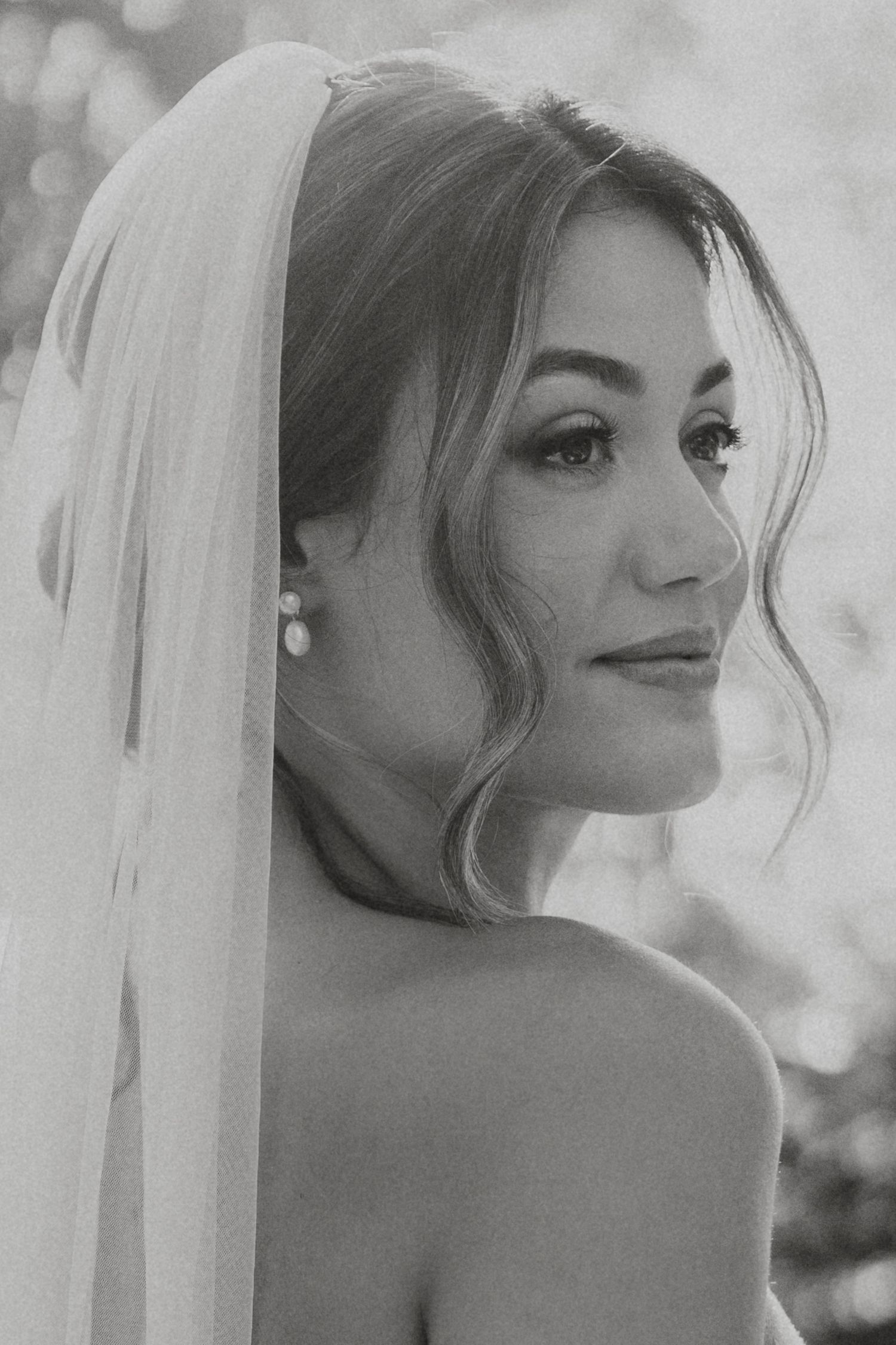 Black and white bridal portraits showing a bride in a veil looking over her shoulder in multiple artistic angles.