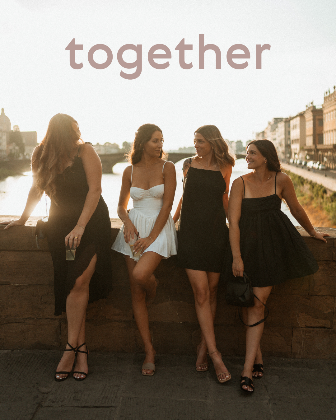 Friends sitting together on a wall at sunset.