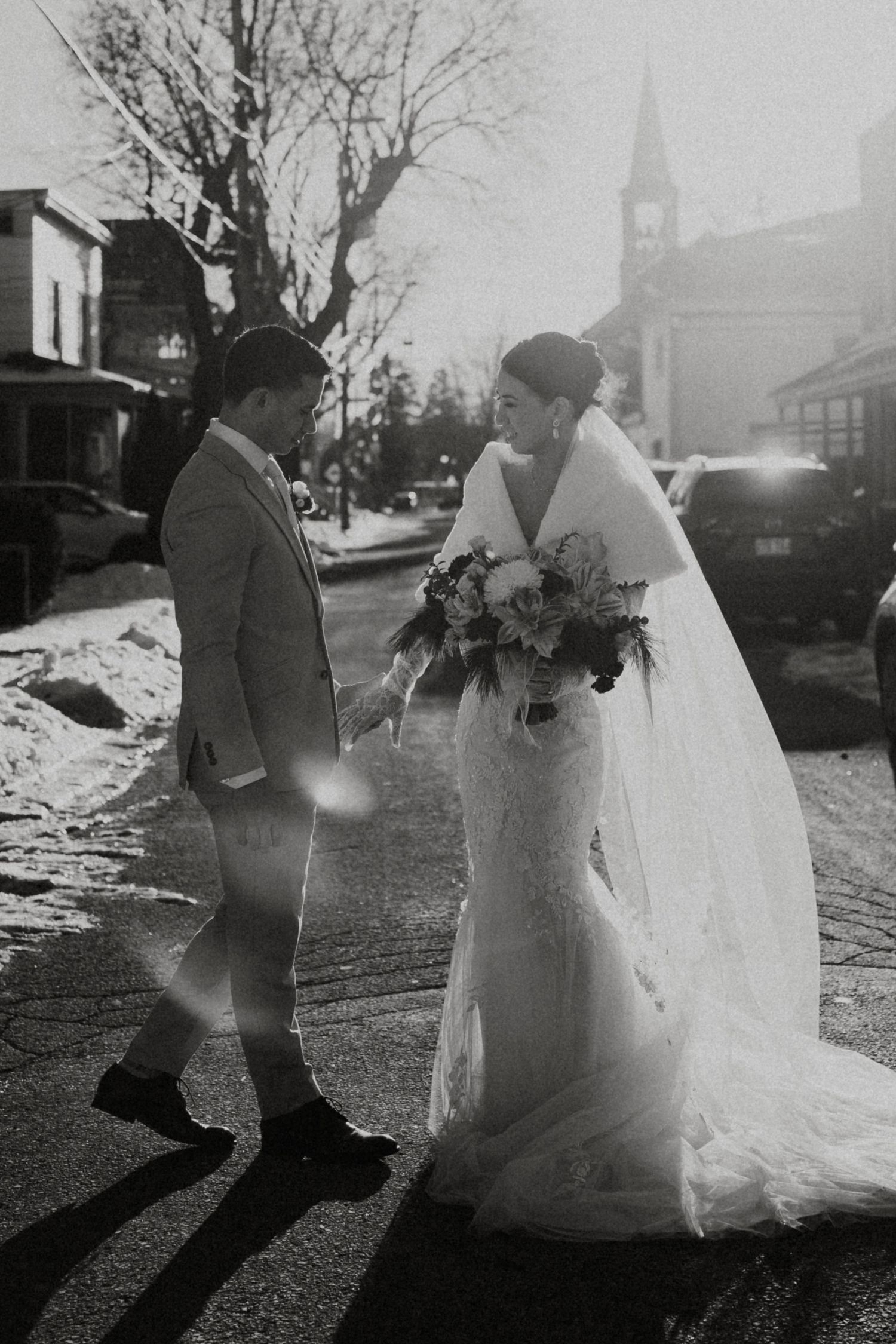 Black and white wedding photos showing couple walking together in elegant attire with church in background.