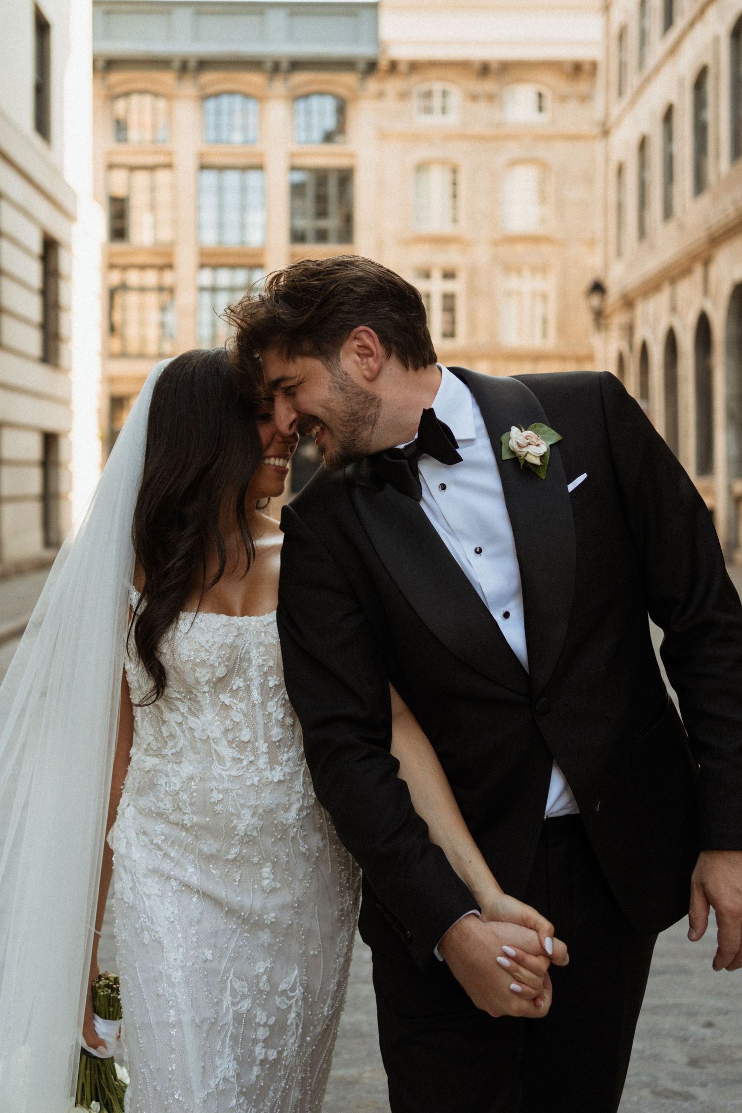 Romantic wedding couple shares intimate moments against a European architectural backdrop.