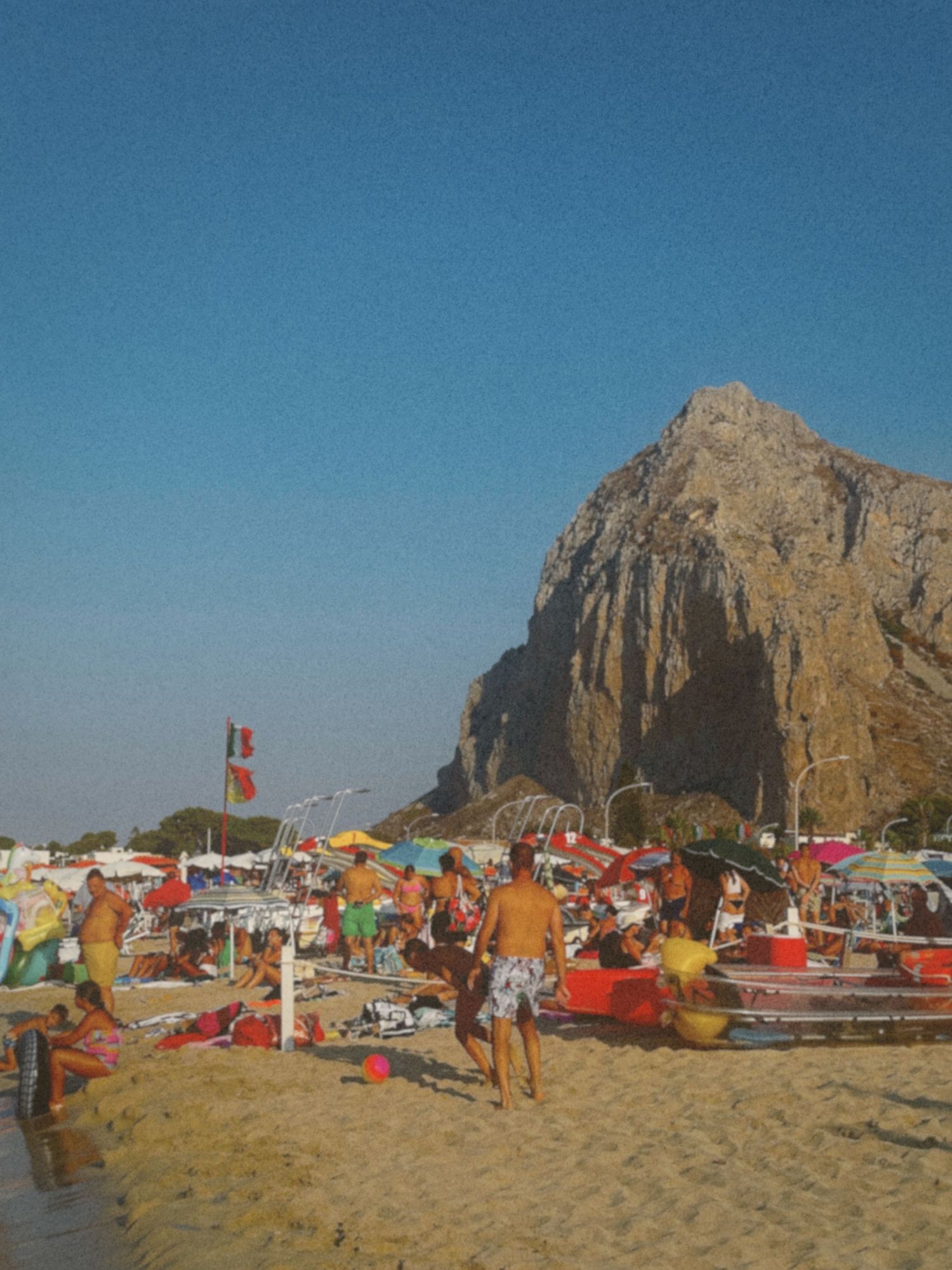 A panoramic sequence of beach scenes with colorful tents and rock formations at Morro Rock Beach in California.