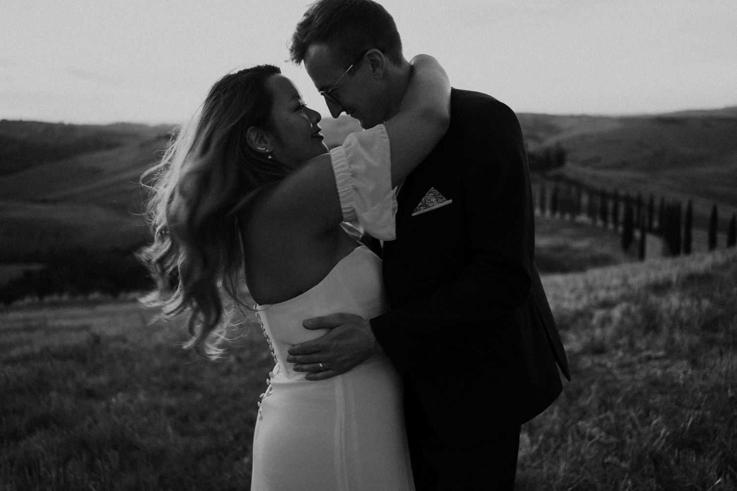 A series of black and white romantic wedding photos showing couples embracing in outdoor settings.