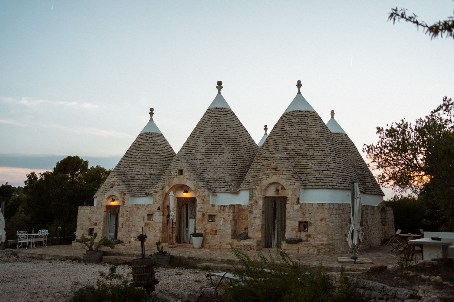 Traditional trulli stone houses with conical roofs at sunset in Alberobello, Puglia, Italy.
