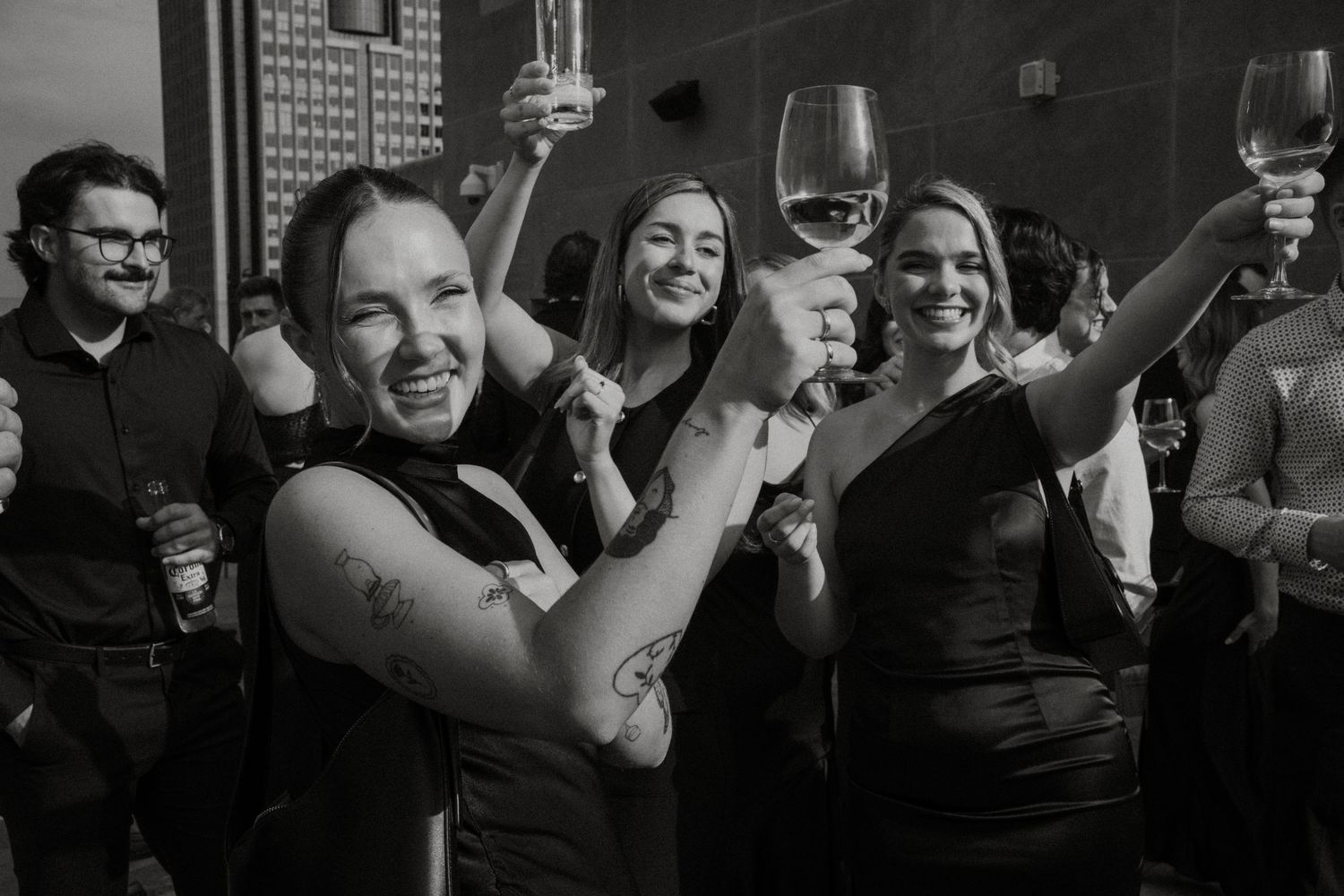 A group of people raising glasses in celebration at what appears to be a party or social gathering.