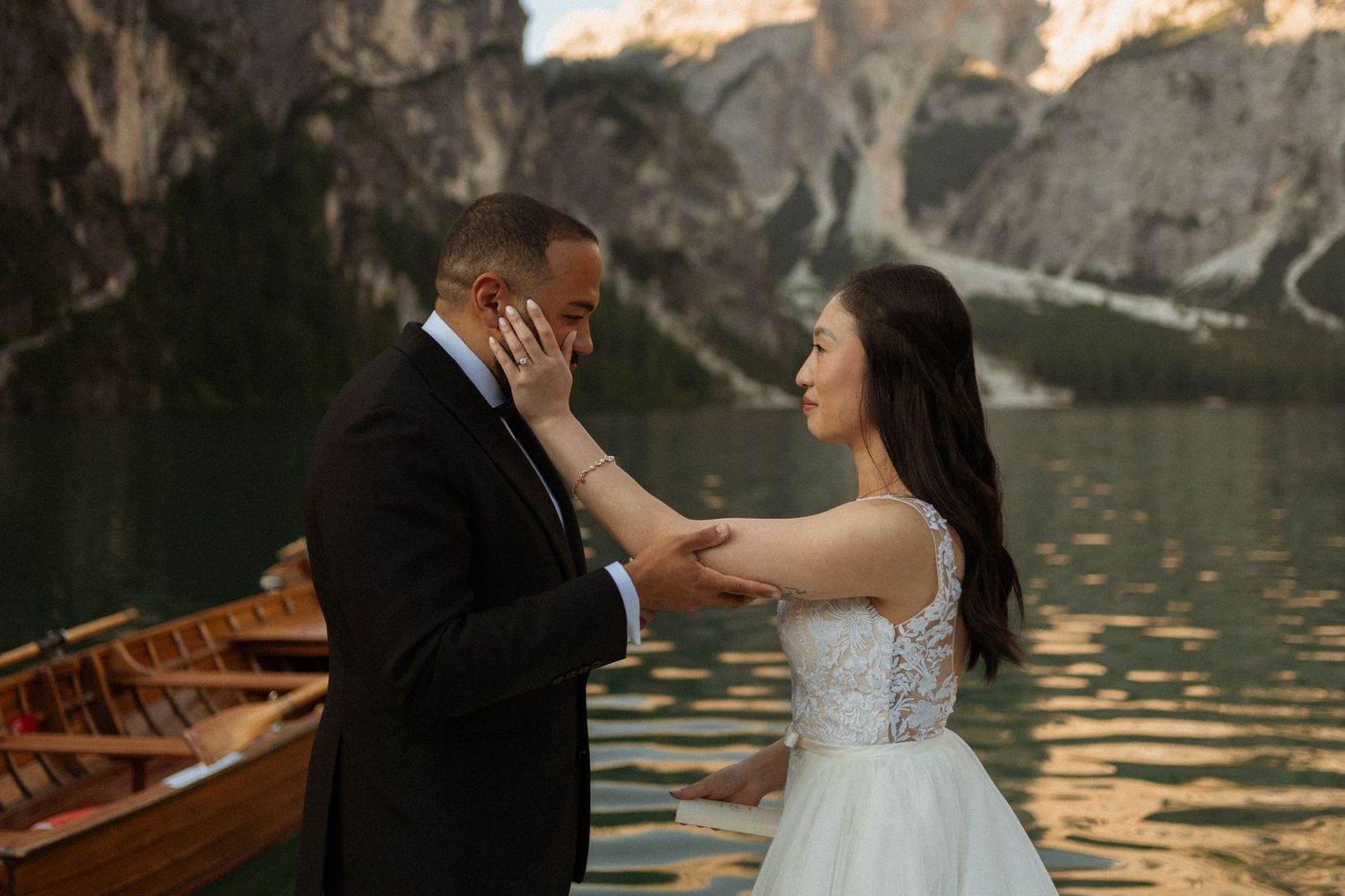 A romantic lakeside moment with mountain backdrop at sunset.