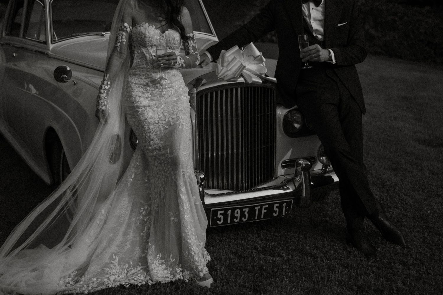 Black and white wedding photos showing couple near vintage car.