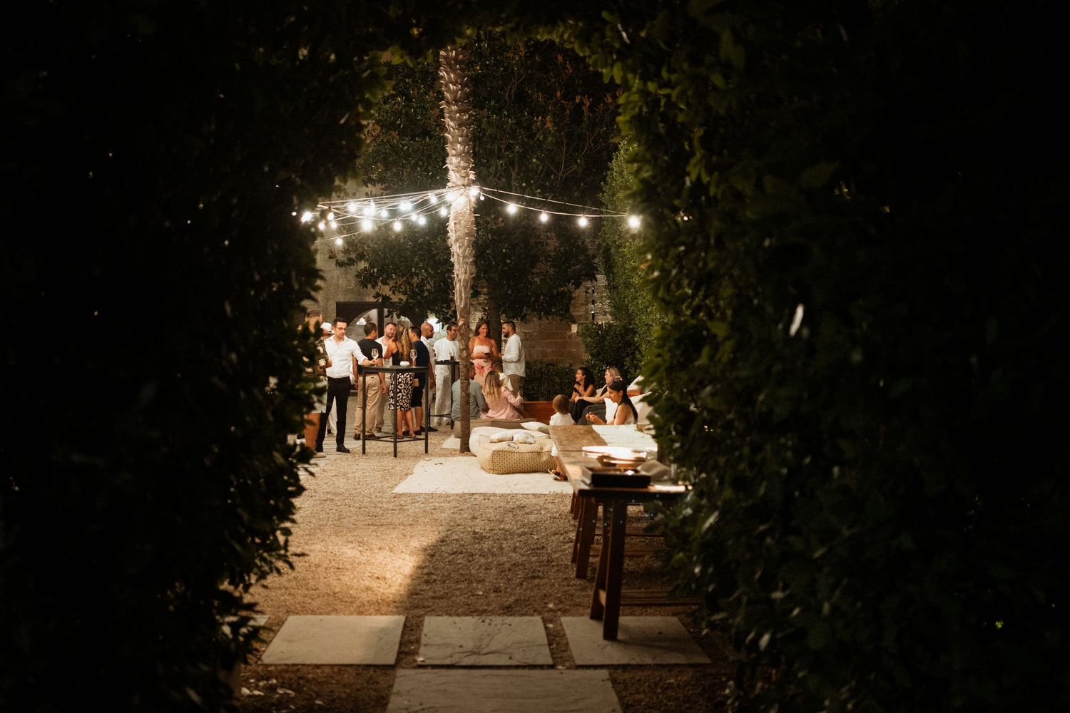 String lights illuminate a romantic outdoor garden path at night creating a magical ambiance.