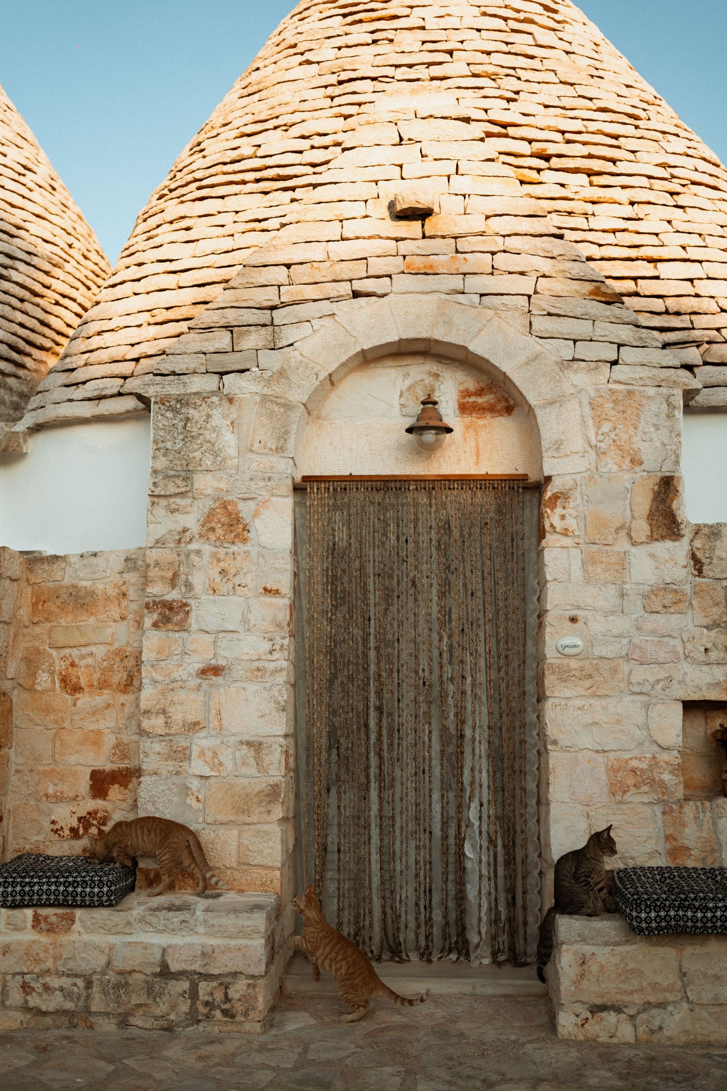 A series of stone archways with rustic wooden doors in a traditional Mediterranean architectural style.
