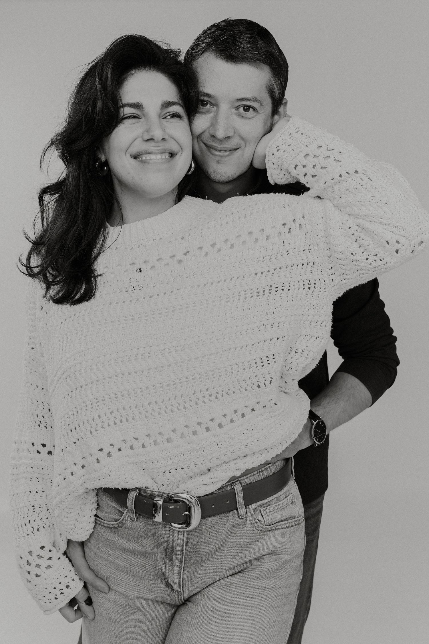 Black and white photo sequence showing playful moments with a white knit blanket.