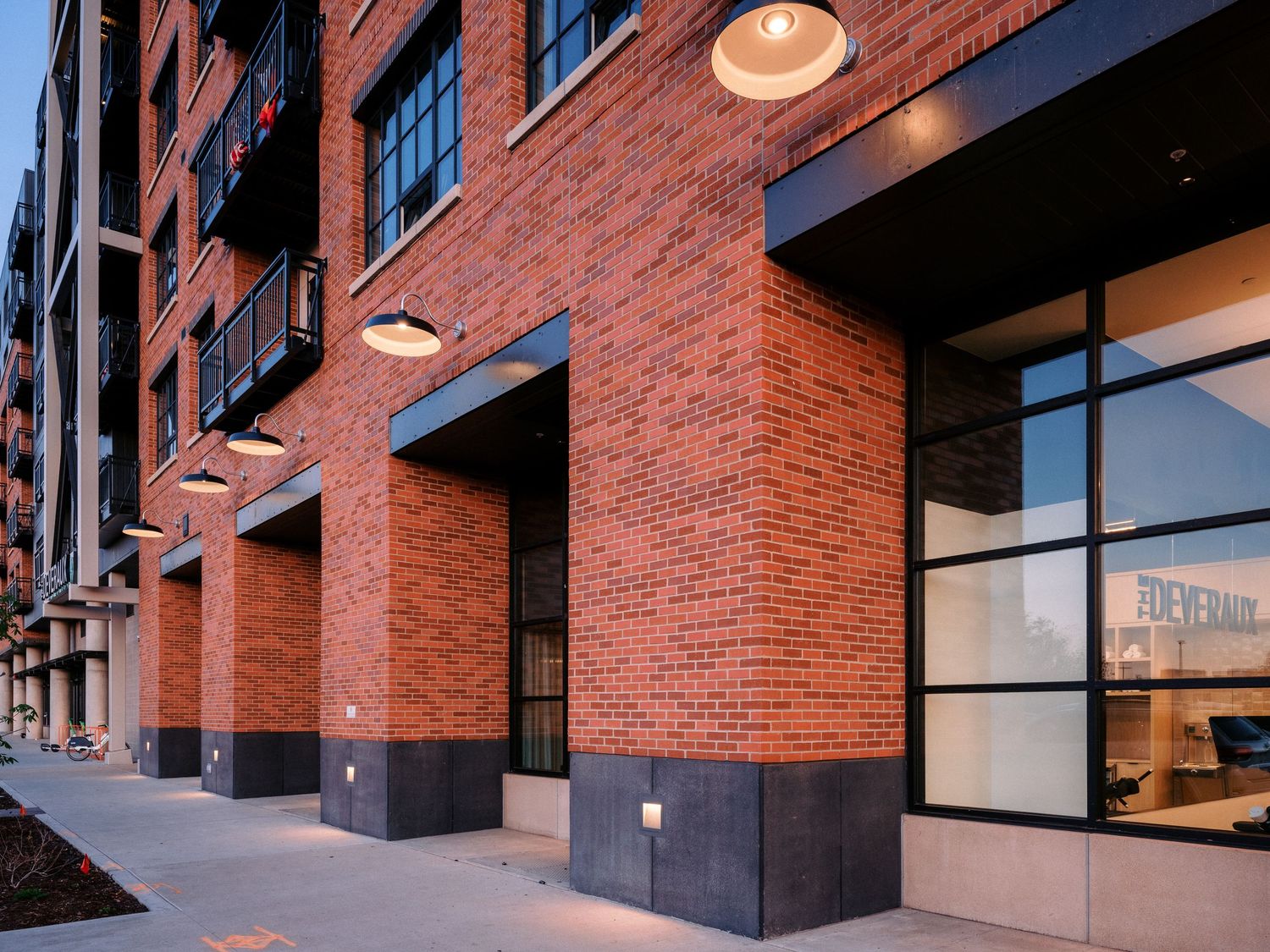 Detail of modern apartment building facade showing brick texture and architectural elements.