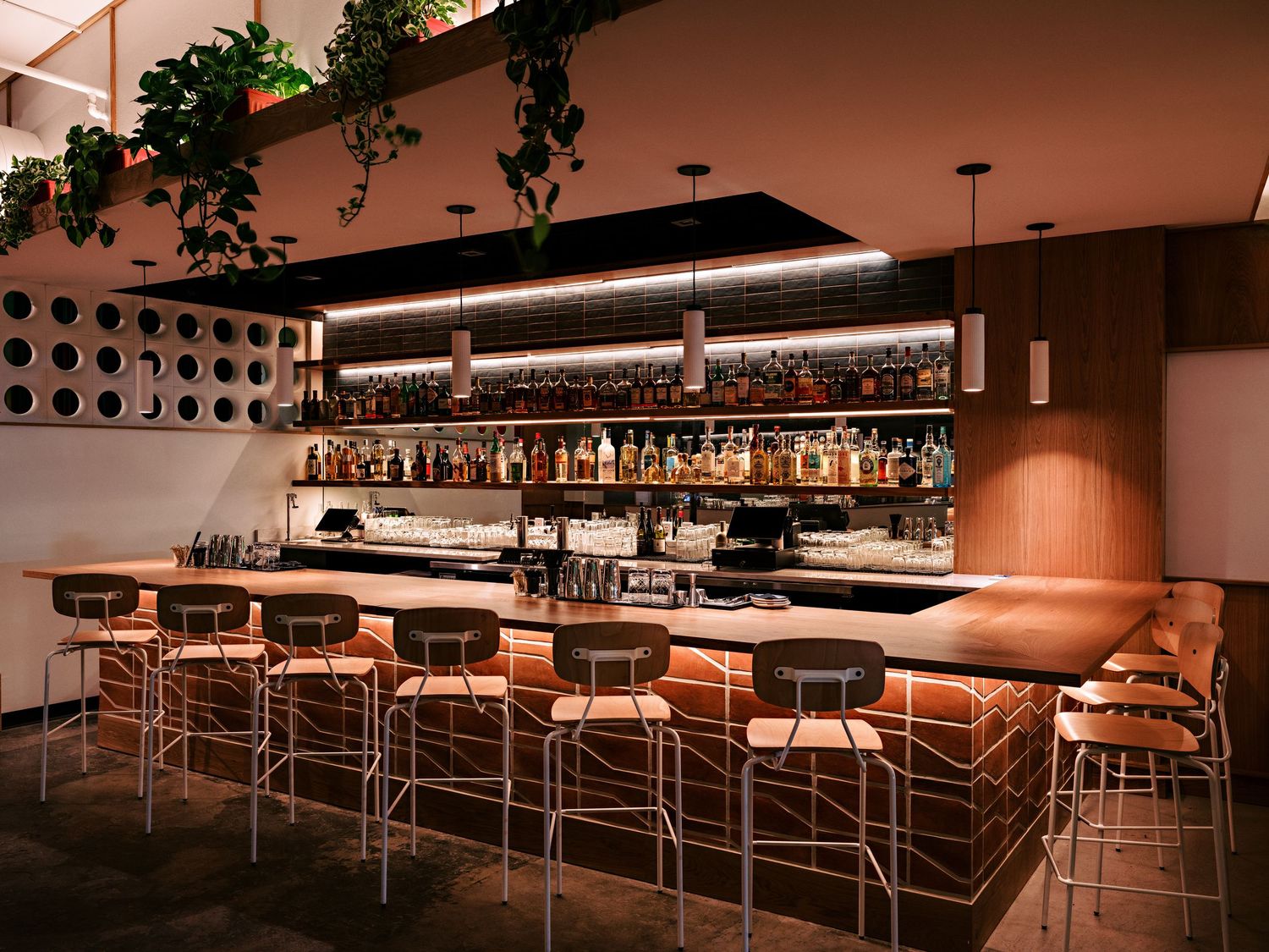 Atmospheric restaurant interior with warm lighting, geometric patterns, and modern architectural details.