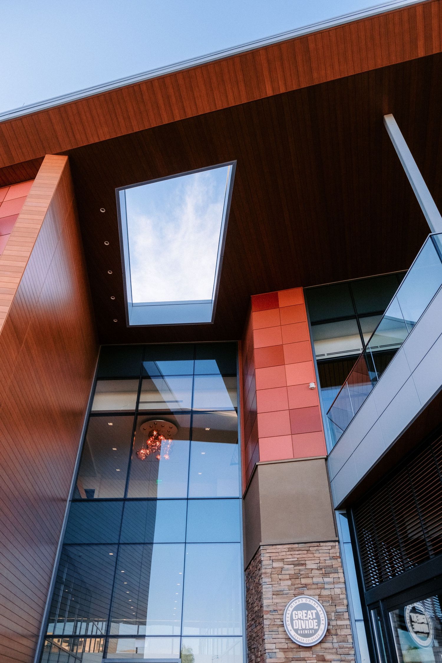 Modern building exterior featuring angular architecture with glass panels and wooden accents.