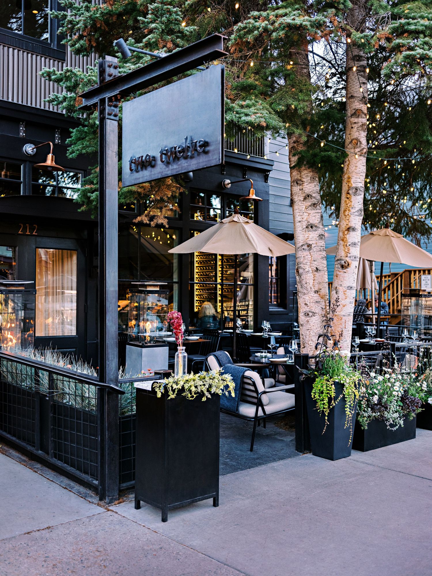 Contemporary restaurant exterior with outdoor patio seating and landscaped planters.