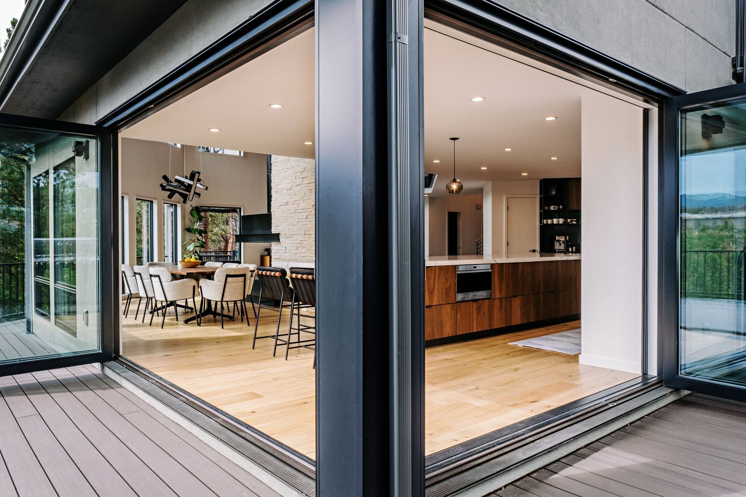 Exterior view of modern house with floor-to-ceiling windows and sliding glass doors.