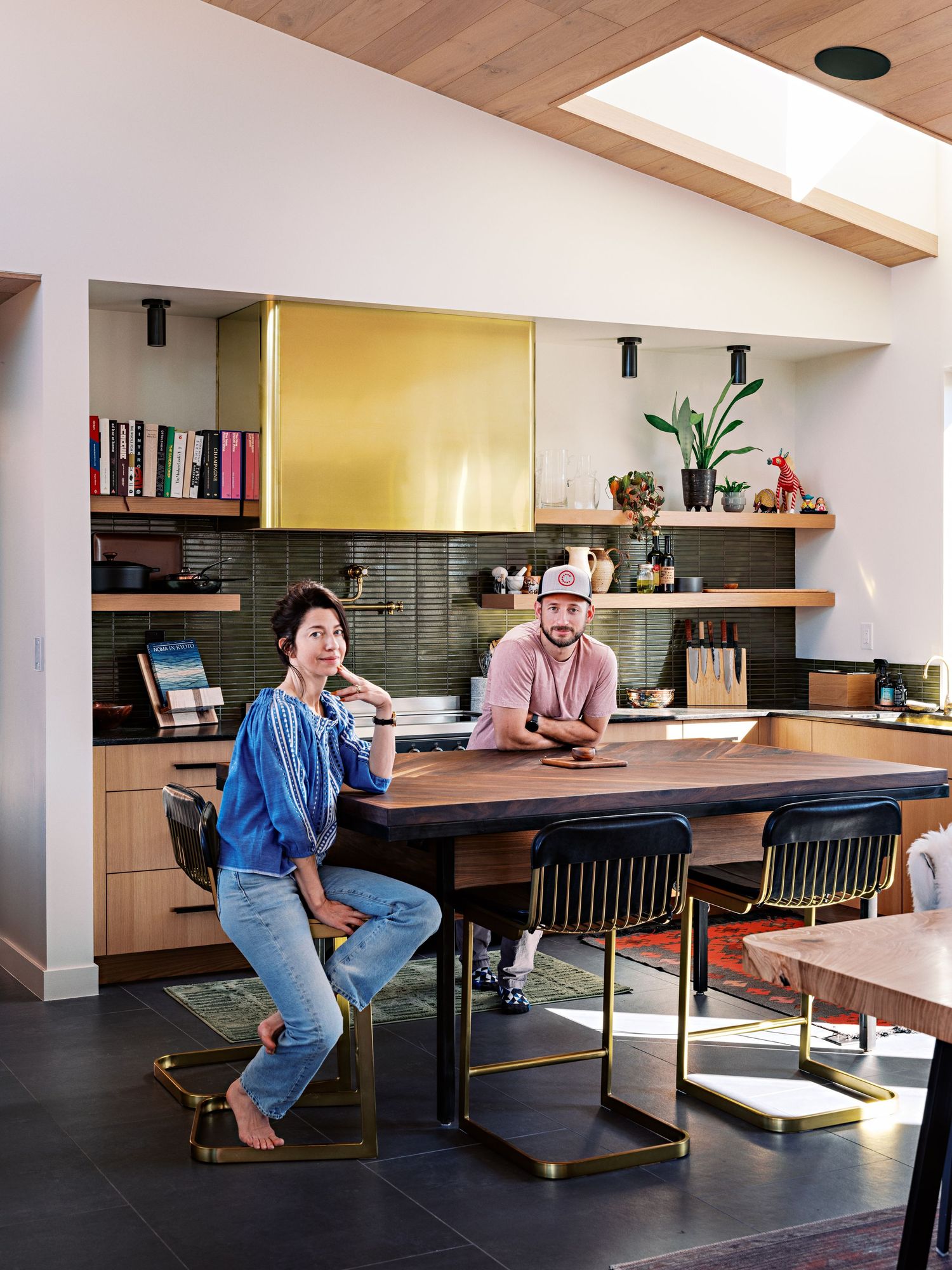 Open concept dining space featuring a long wooden table with bench seating and natural lighting.