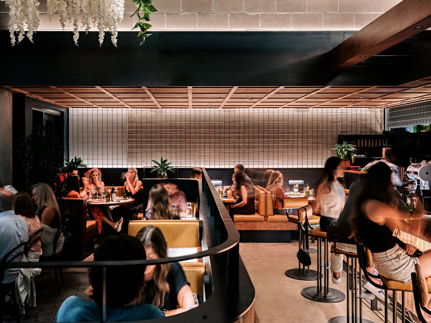 Dimly lit restaurant interior with curved booths and bar seating.