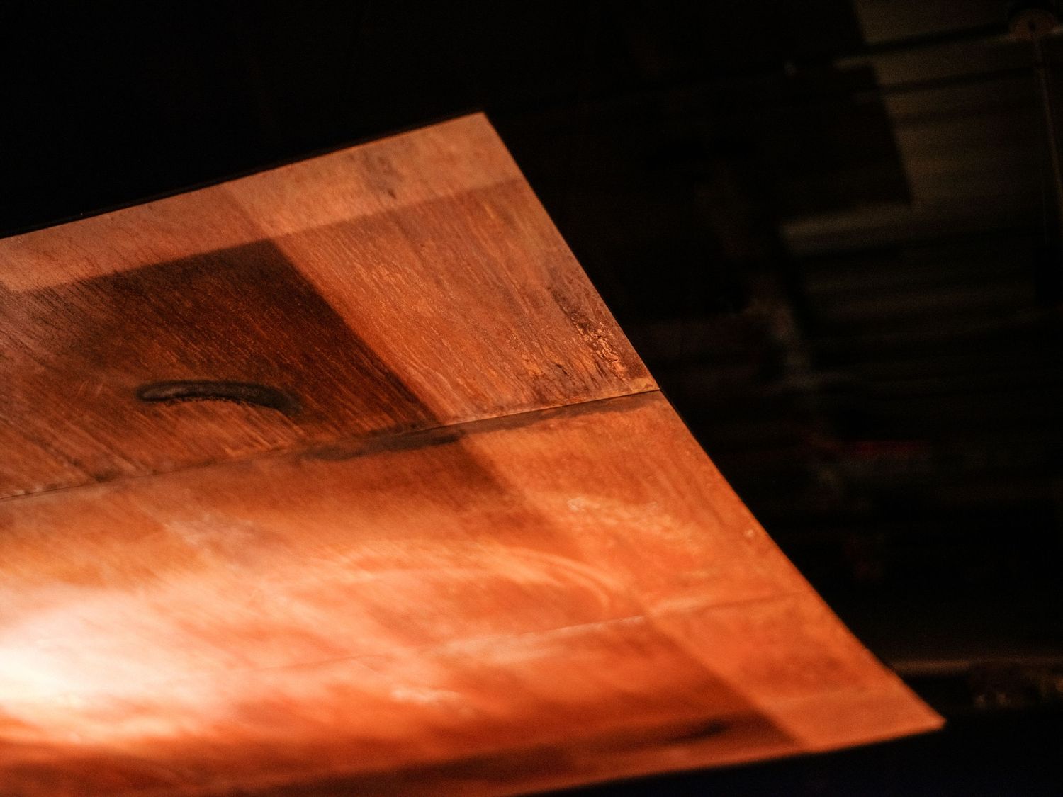Abstract pattern of warm orange light and shadows on a textured surface.