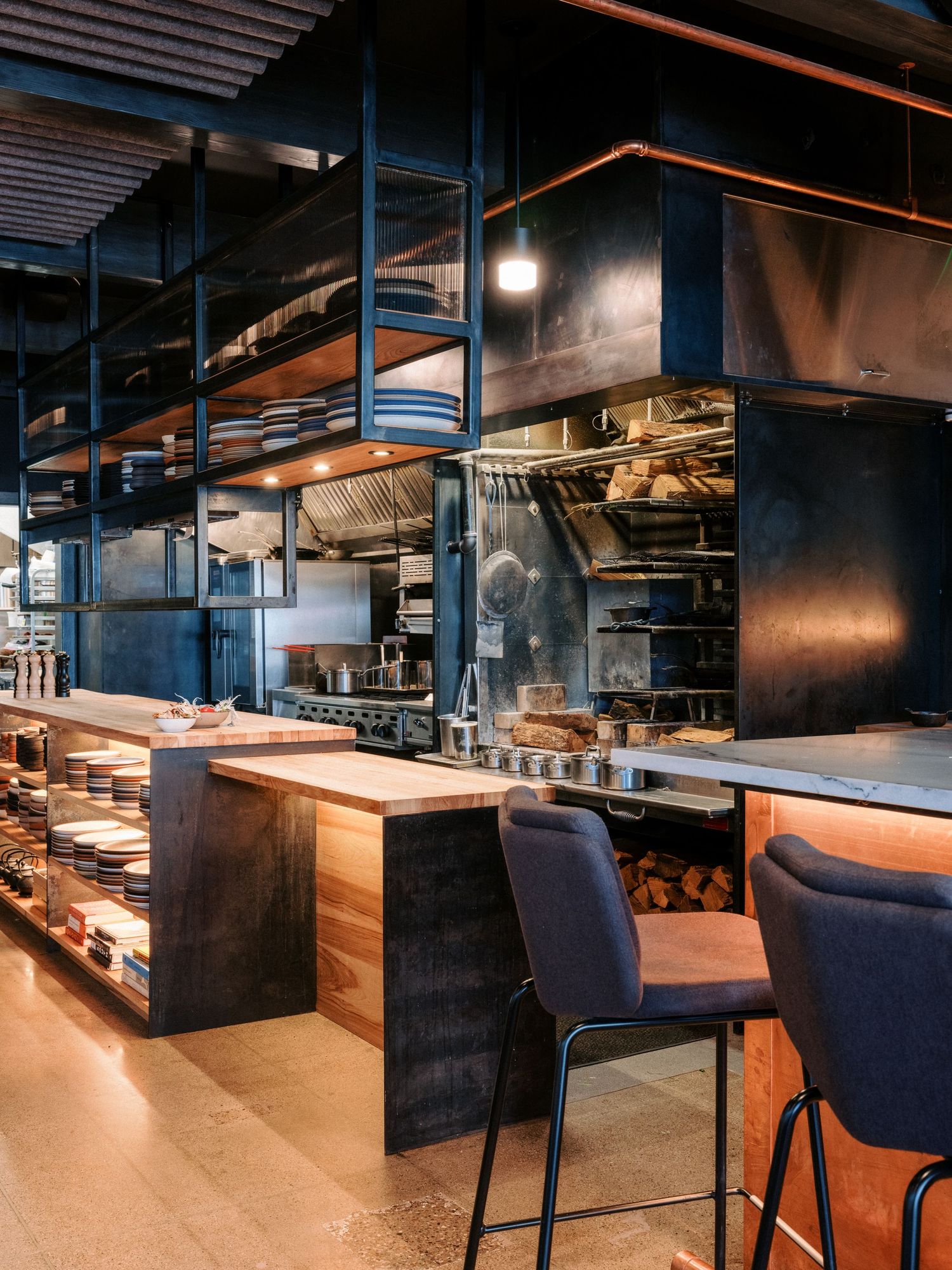 Industrial-style dining area with navy blue chairs and wooden accents.