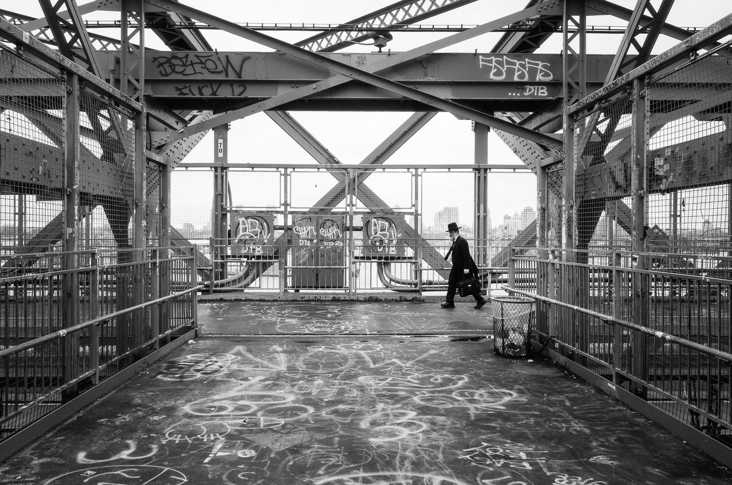 Industrial walkway with metal railings and structural beams extends across a factory interior space.