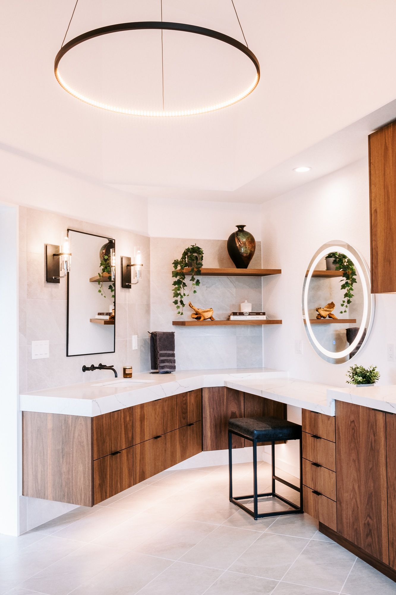 Contemporary white kitchen with wooden cabinets, circular lighting, and floating shelves.