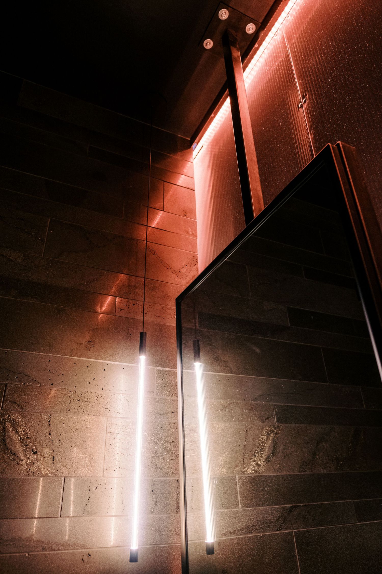 Minimalist hallway with vertical LED light fixtures mounted on concrete walls.