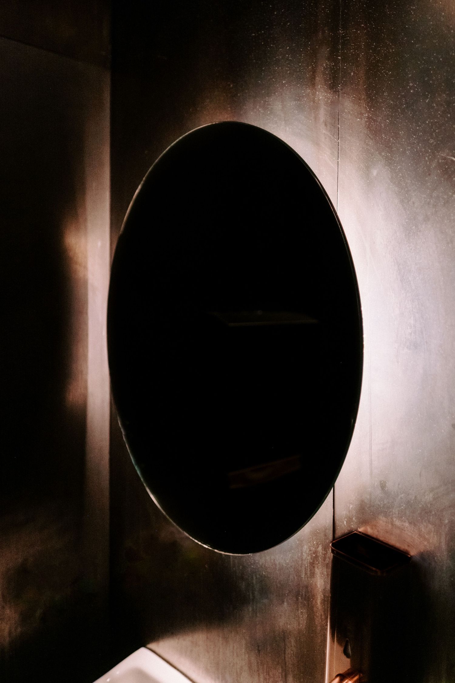 Series of circular openings in a dark wall creating an artistic architectural element.