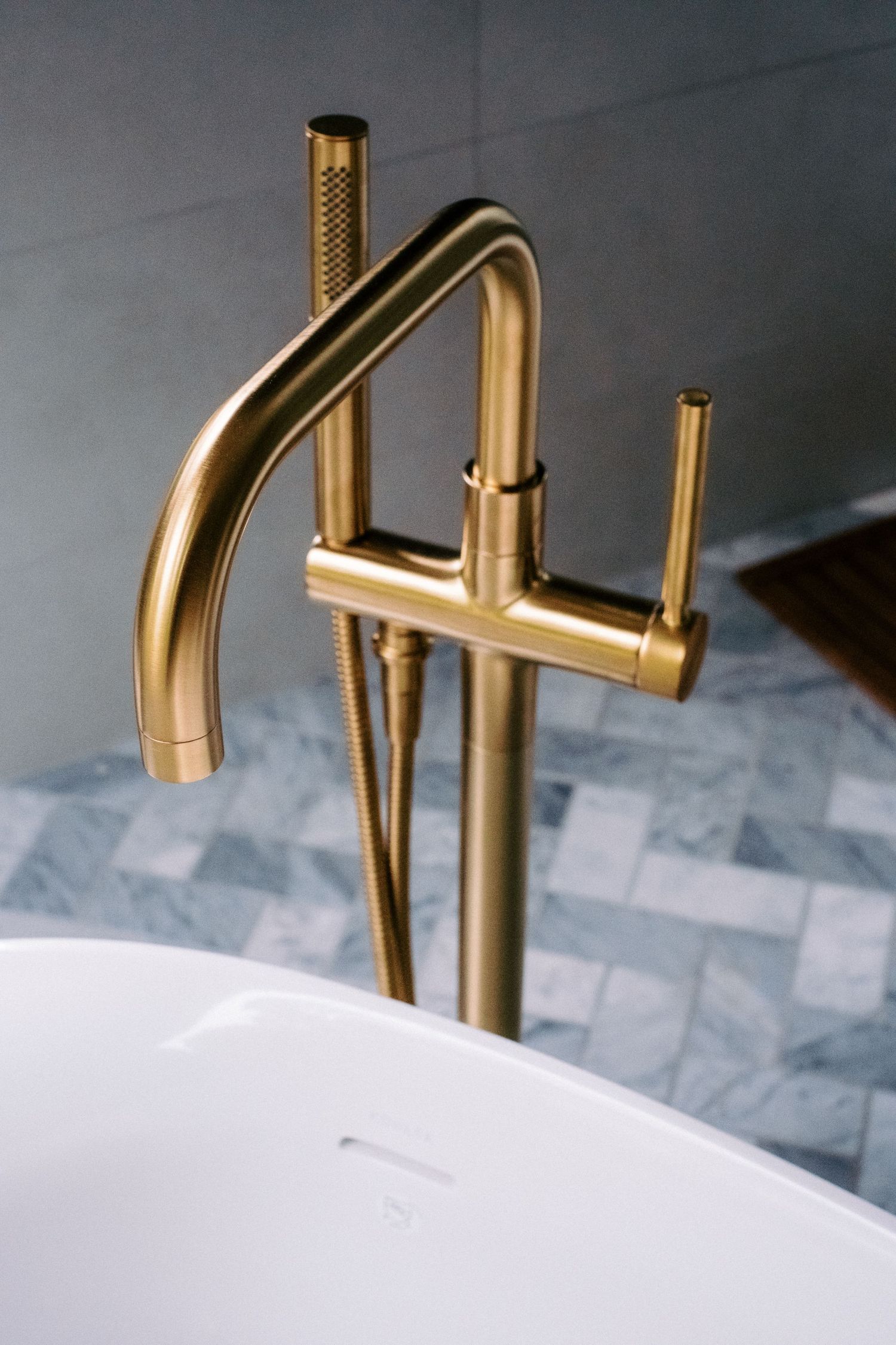 Luxurious brass bathroom faucet mounted on white marble surface.