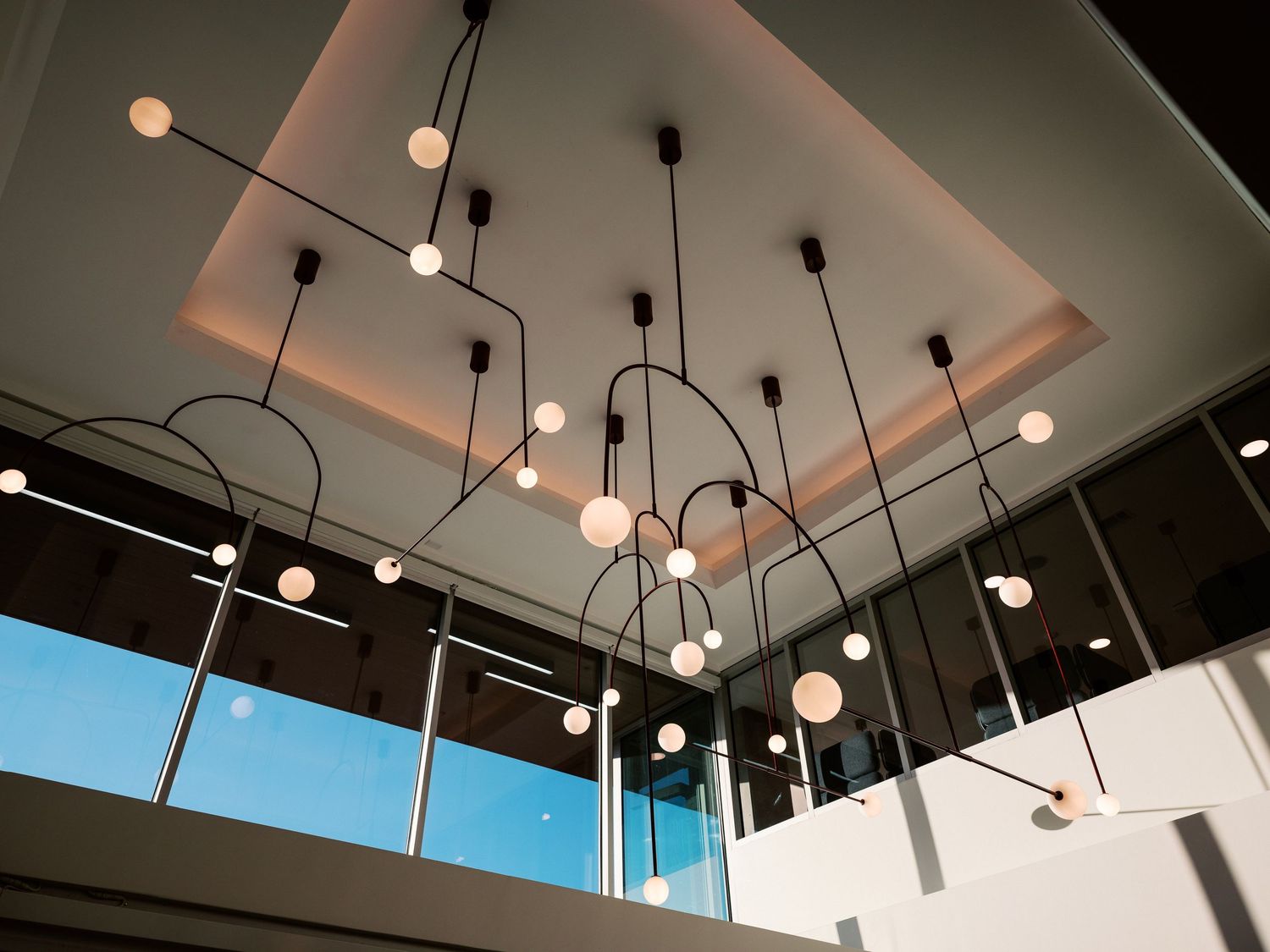 Modern ceiling light installation with multiple hanging pendant lights in geometric arrangement.
