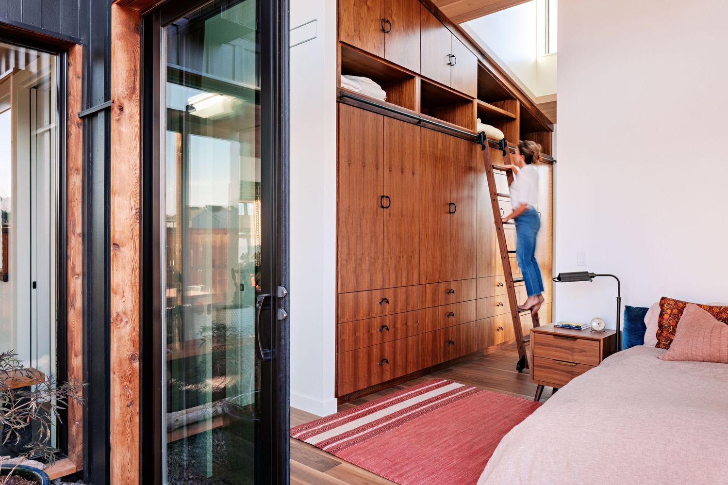 Exterior deck space with wooden flooring and glass sliding doors connecting to interior living area.
