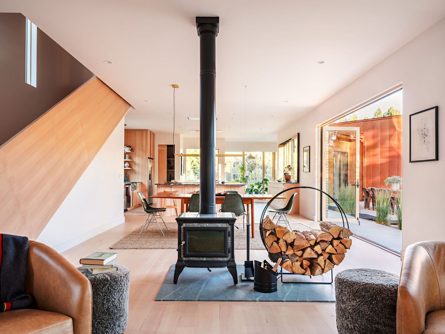Open concept living space with wood stove and modern furnishings in natural light.