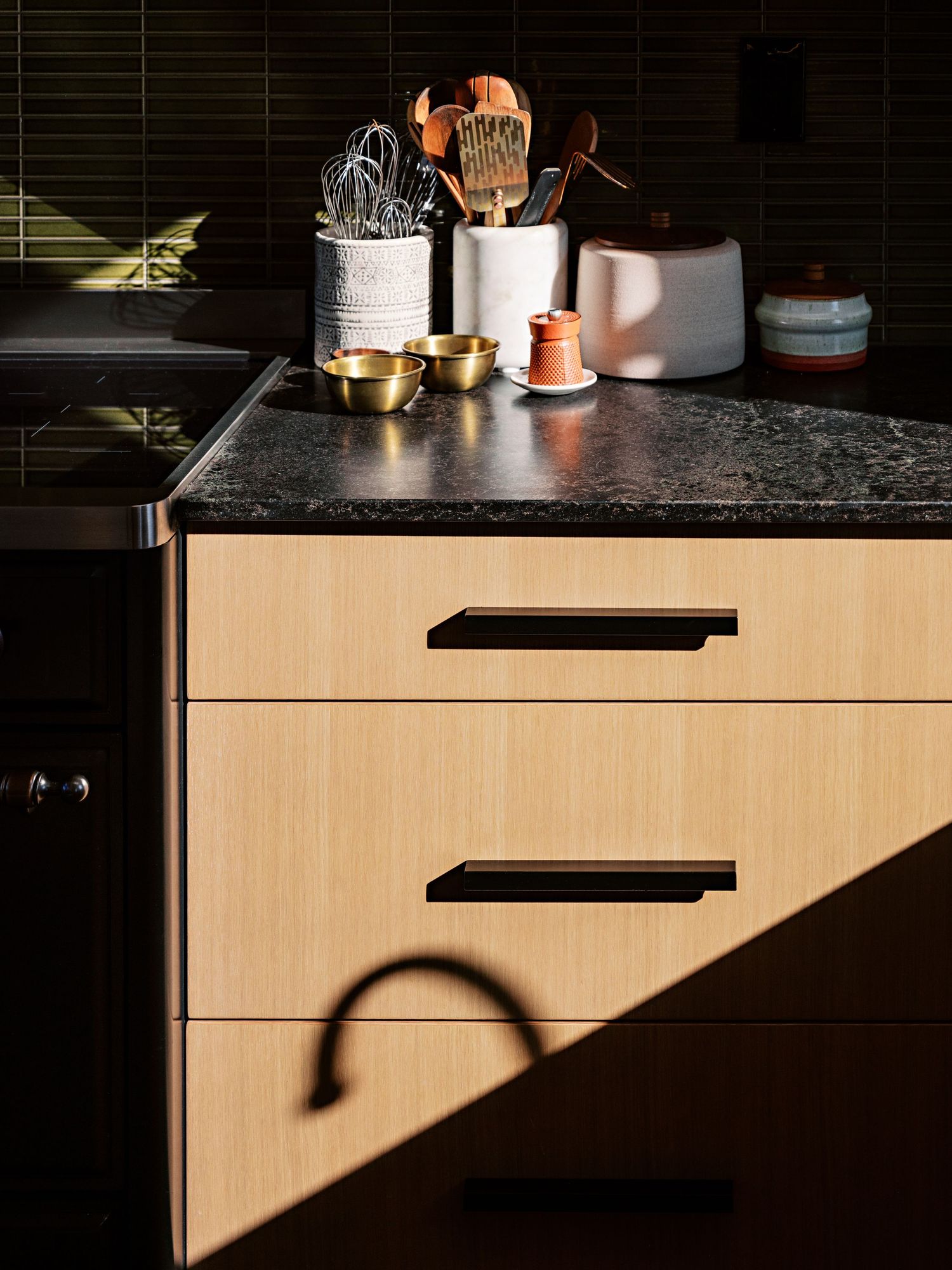 Artistic close-up of kitchen cabinets with dramatic shadows and lighting effects.