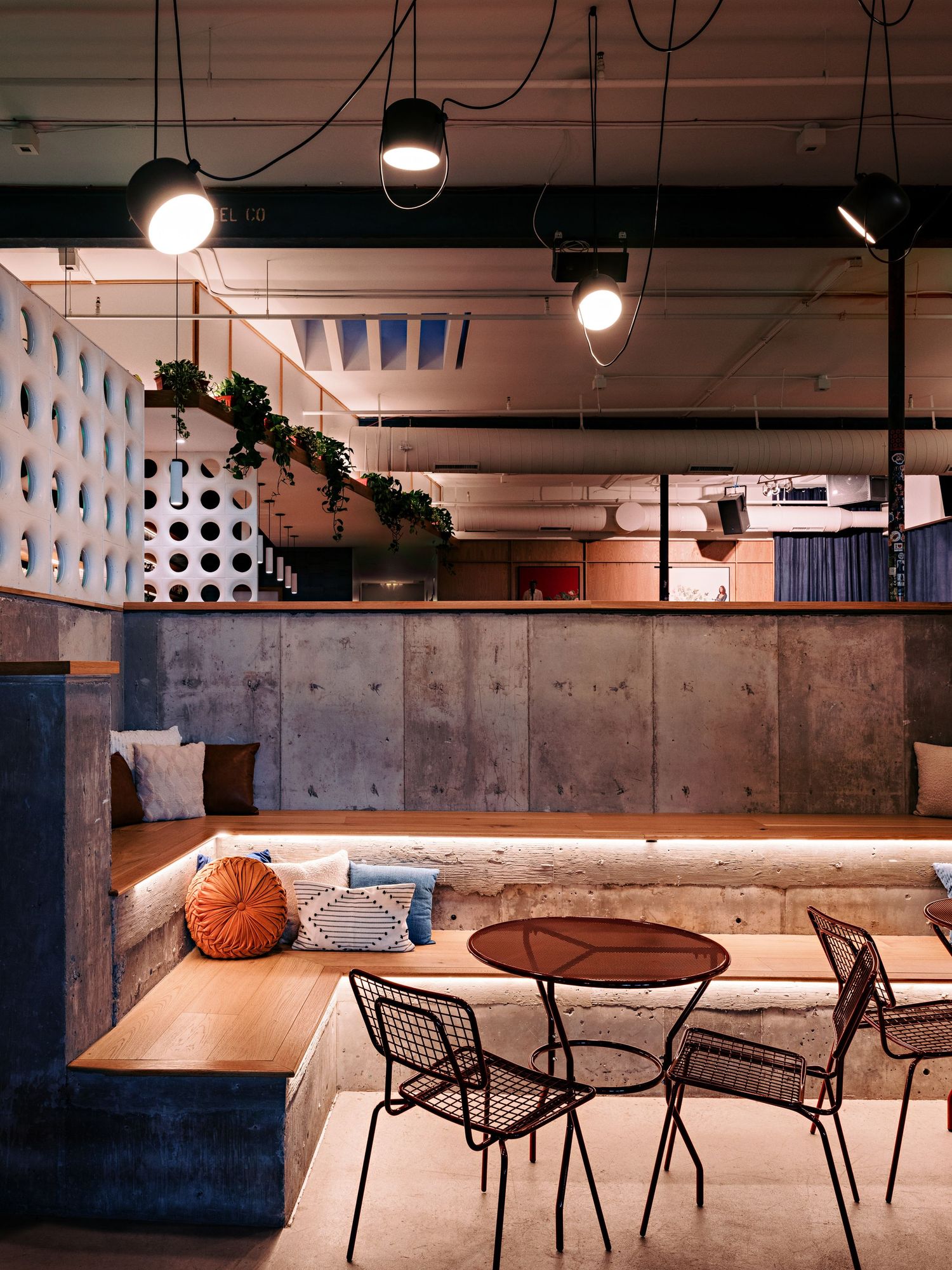 Contemporary dining room with industrial elements, pendant lighting, and geometric design features.