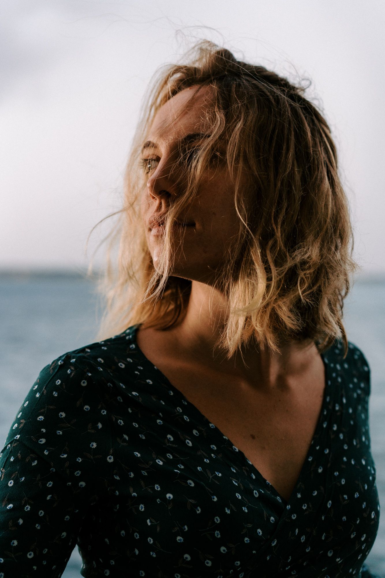 Artistic sequence of windswept hair against ocean backdrop in soft lighting.