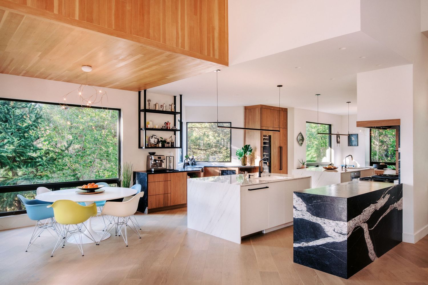 Modern kitchen featuring warm wood cabinets and white island with sleek appliances and open layout design.