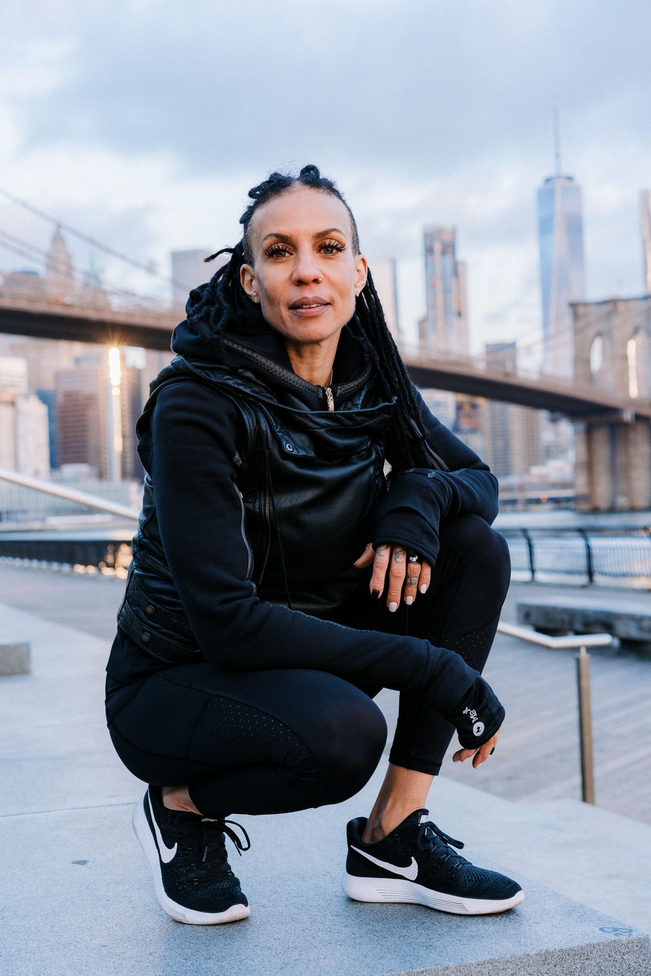 Urban fashion portrait with city skyline background and athletic wear.