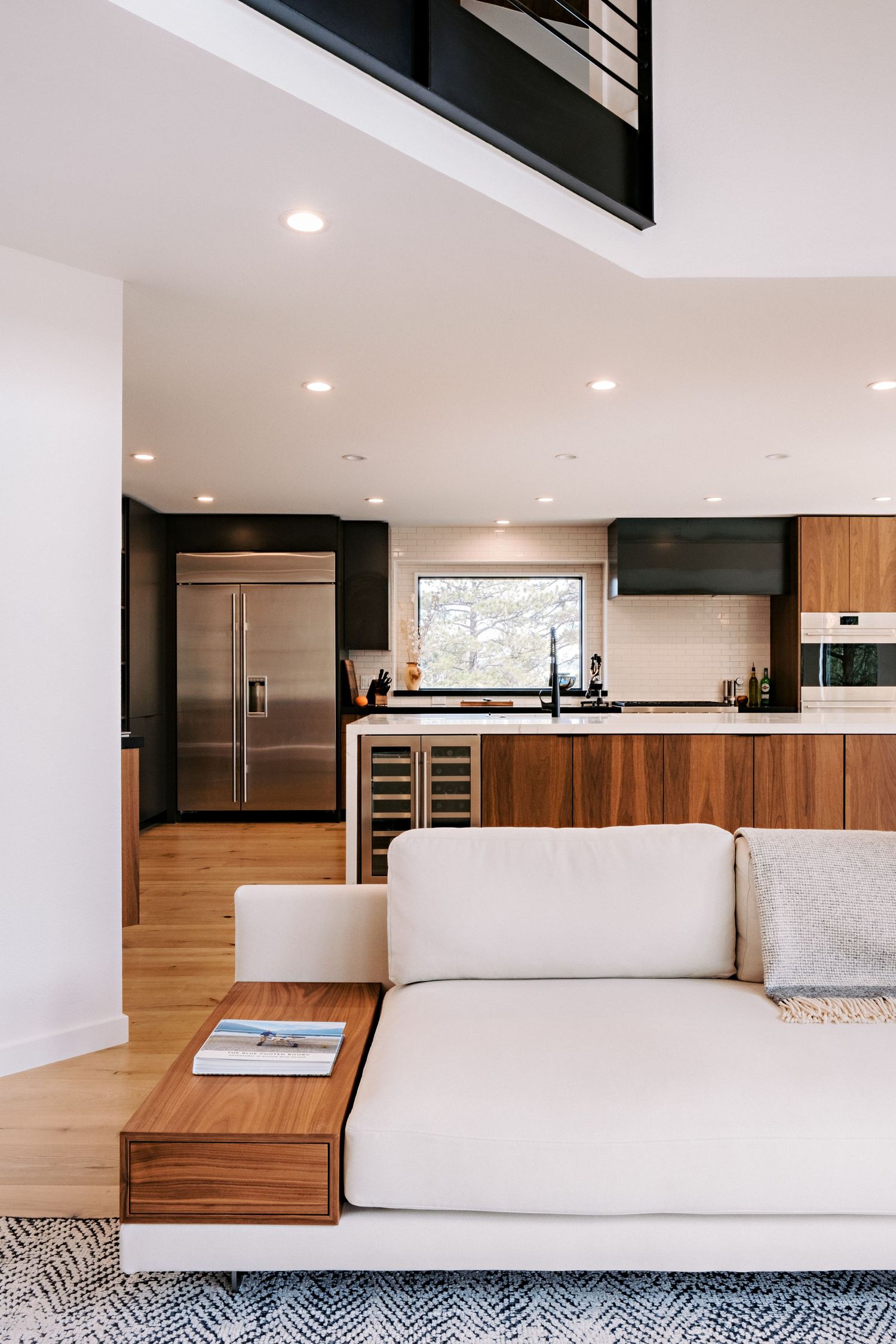 Open concept living space with white sectional sofa and built-in wooden storage features.