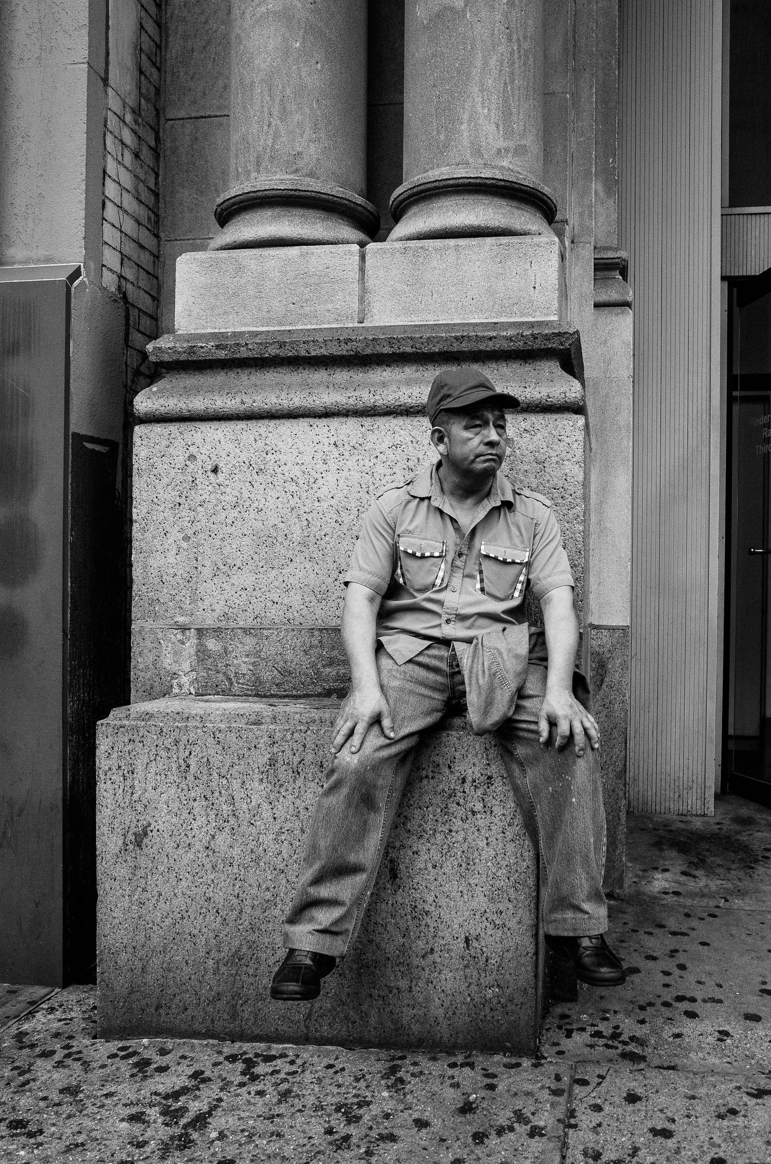 A black and white triptych photograph shows a person sitting on a ledge in different positions against stone columns.