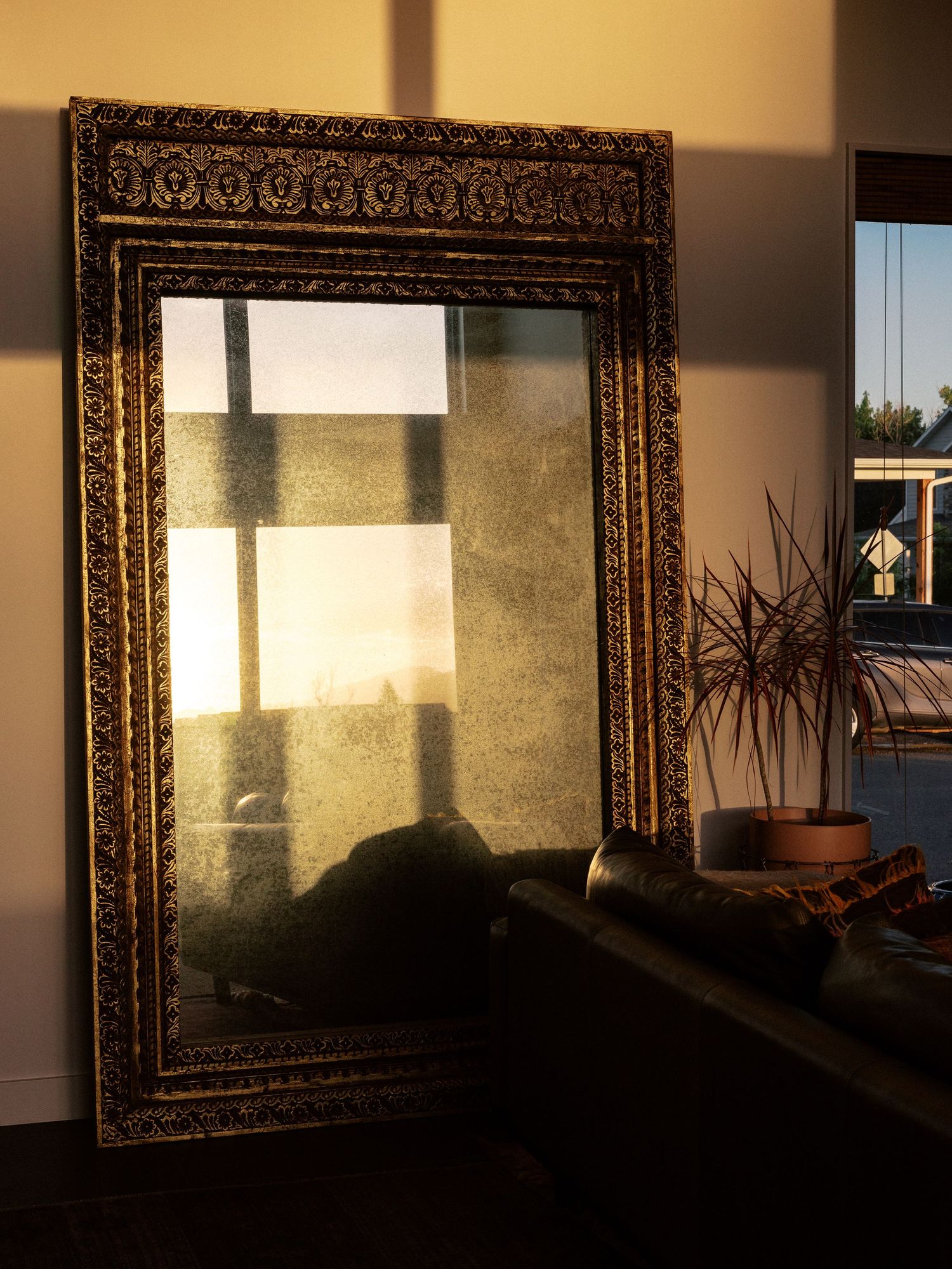Ornate gold-framed mirrors creating dramatic shadows in contemporary interior space.