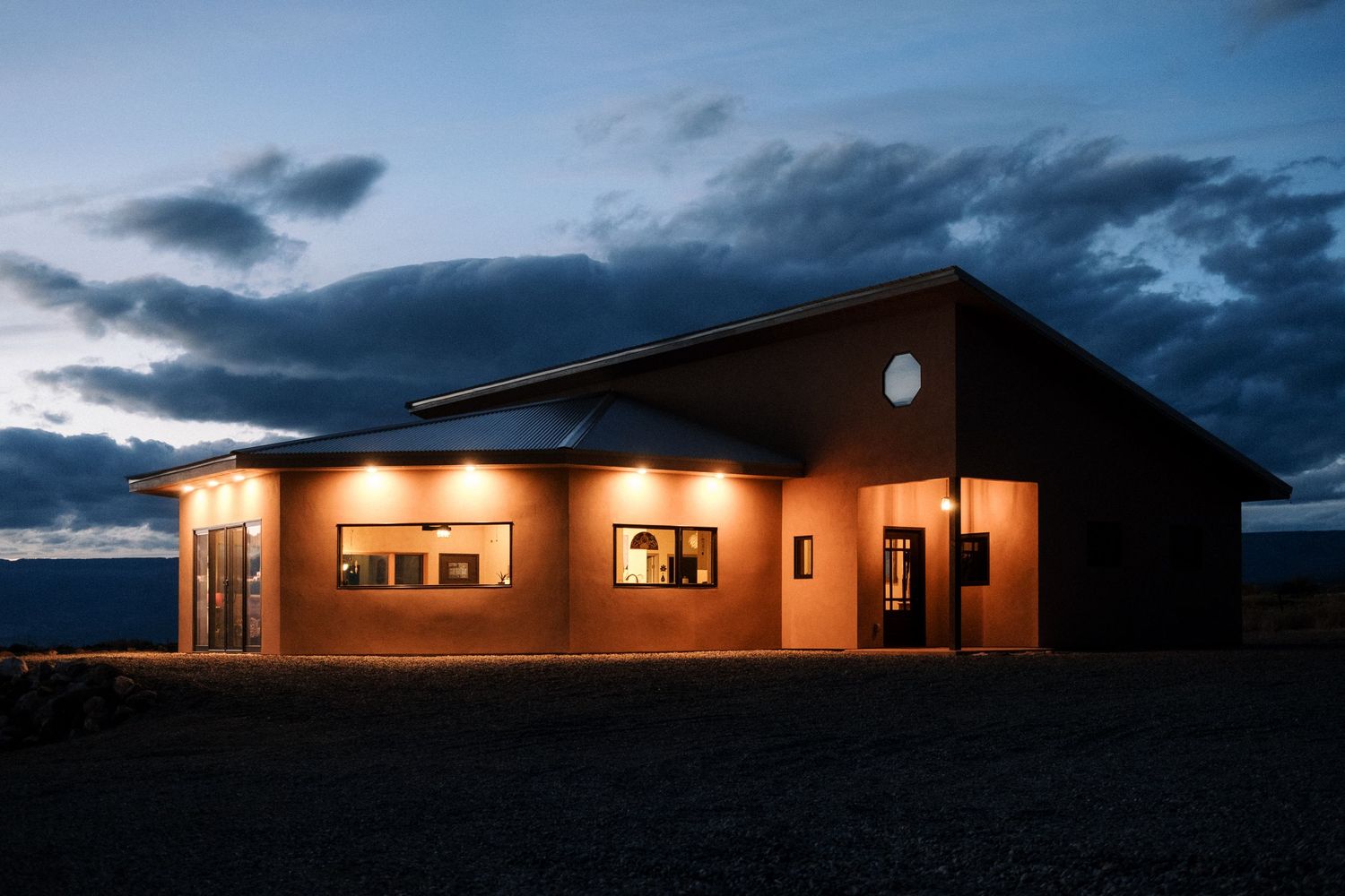 Illuminated building exterior against dramatic twilight sky.