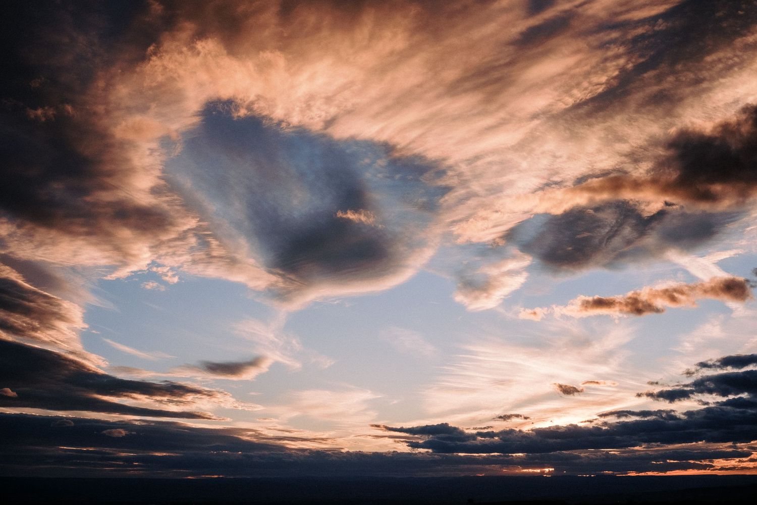 Dramatic sunset sky with unique cloud formation creating contrast between dark and light.