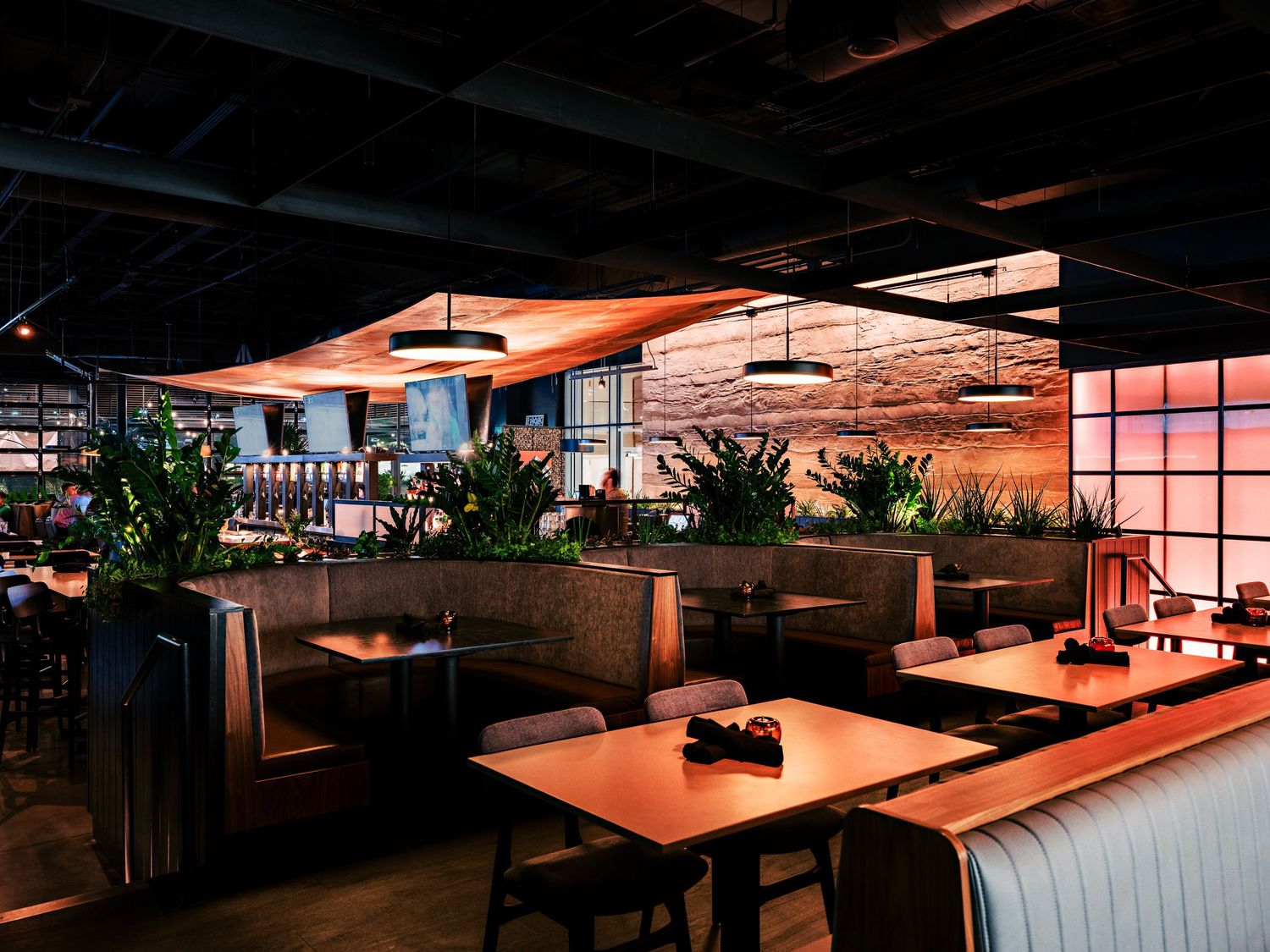 Spacious dining area with modern furniture and warm atmospheric lighting.