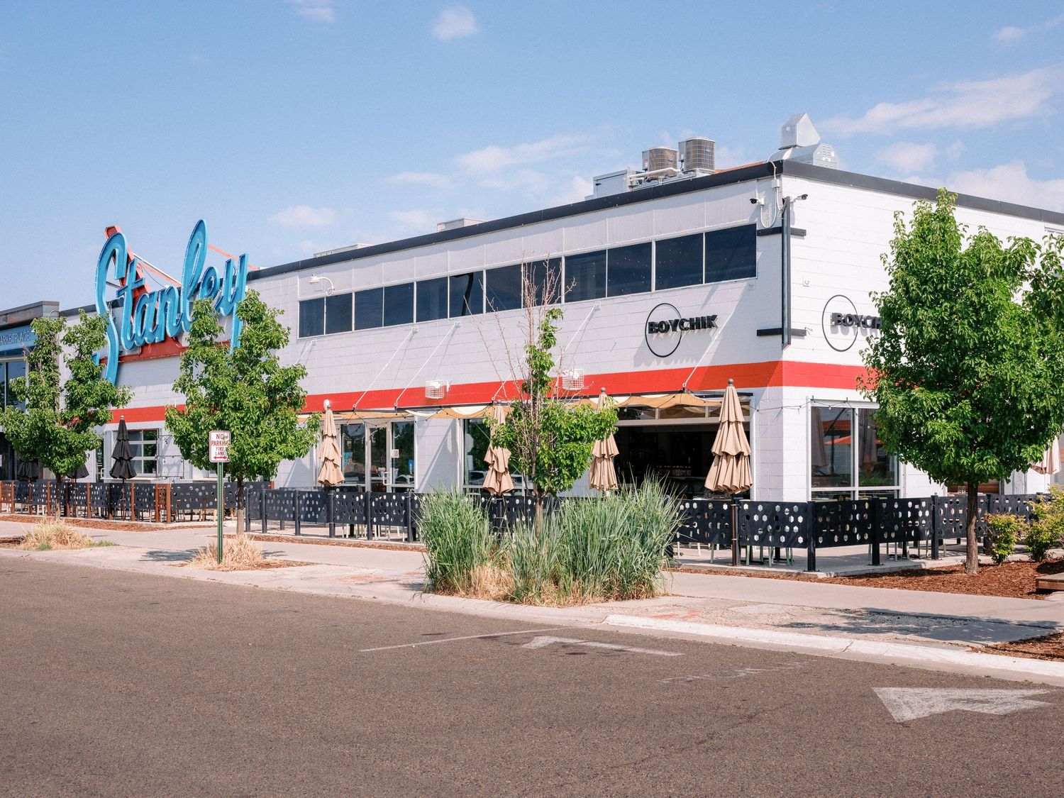 Panoramic view of a commercial plaza with landscaping and outdoor dining area.