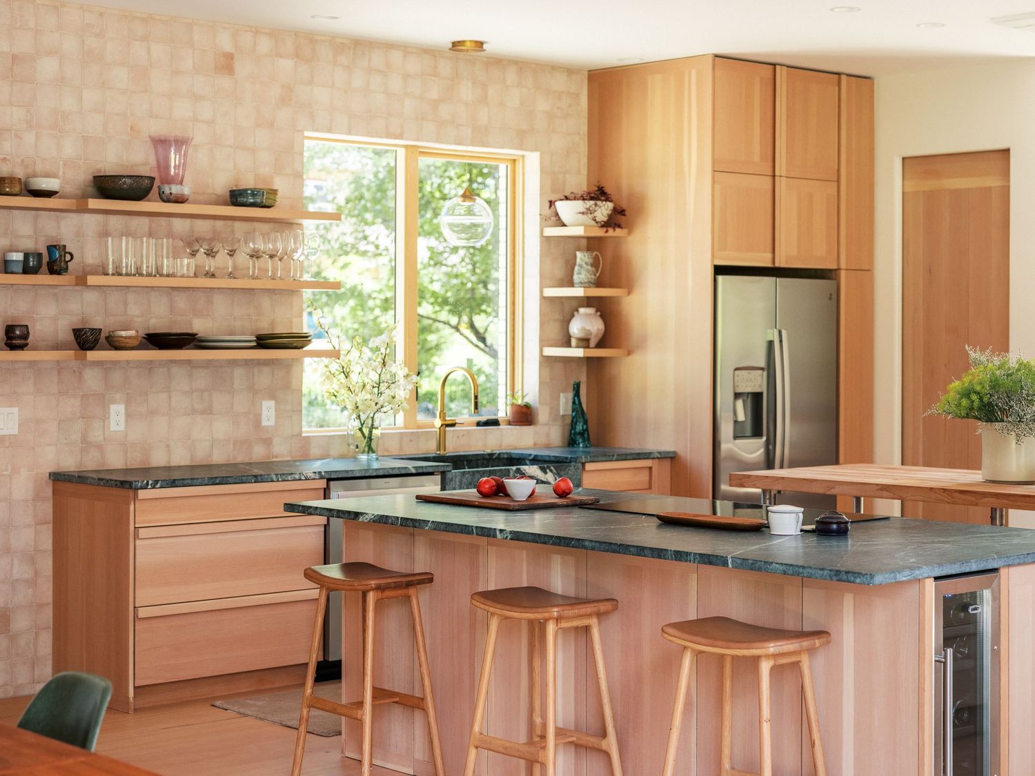 Contemporary open concept kitchen with wood cabinets, island seating, and brick accent wall.