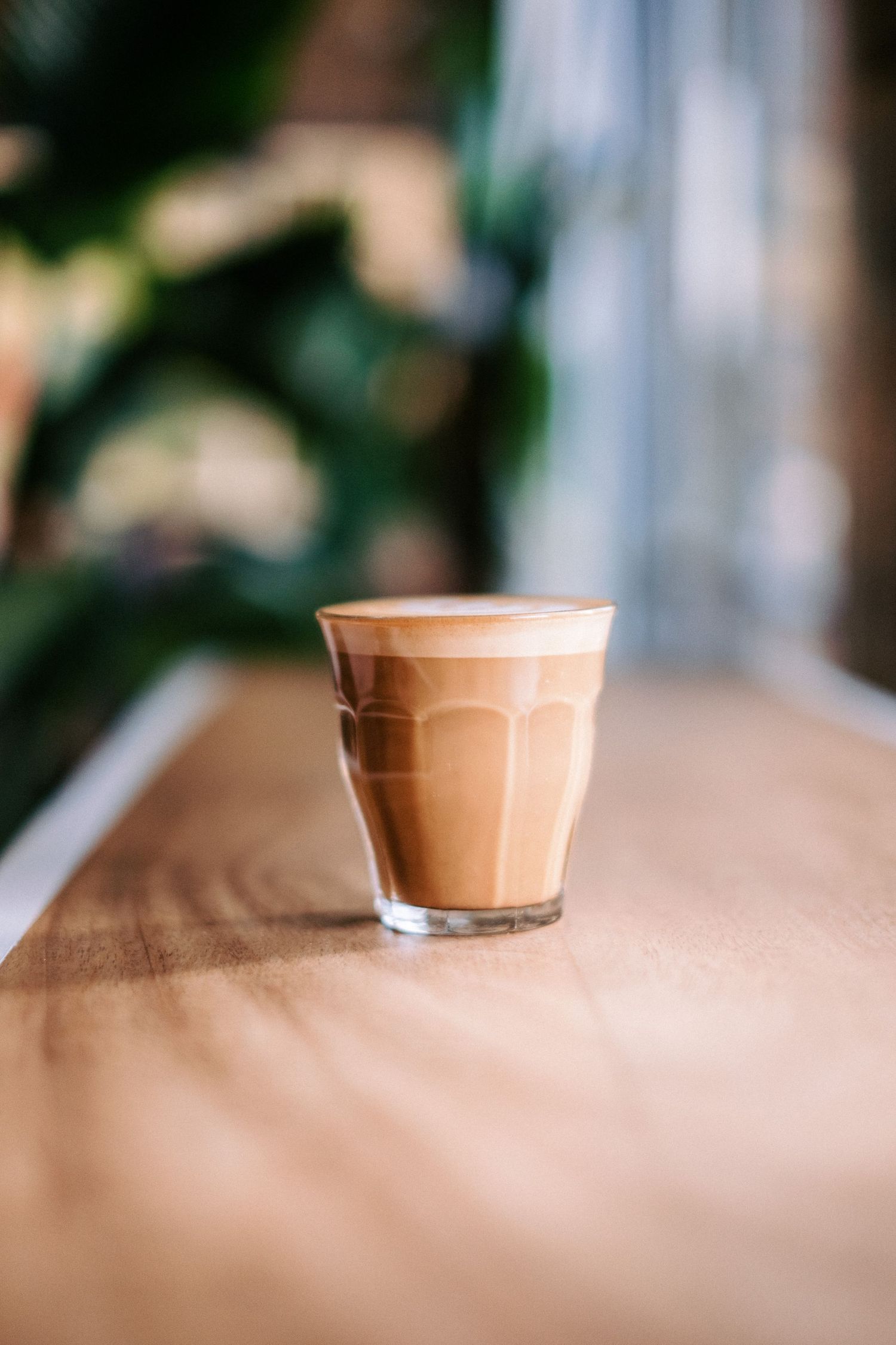 Close-up of latte coffee in ceramic cup on textured surface.