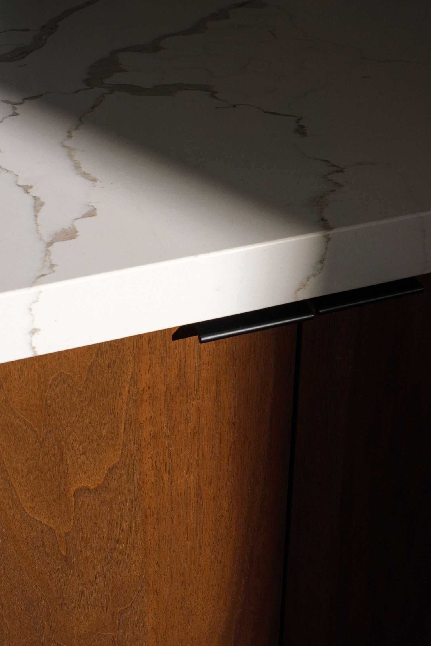 Close-up of wood grain detail against white marble-like surface showing elegant material contrast.