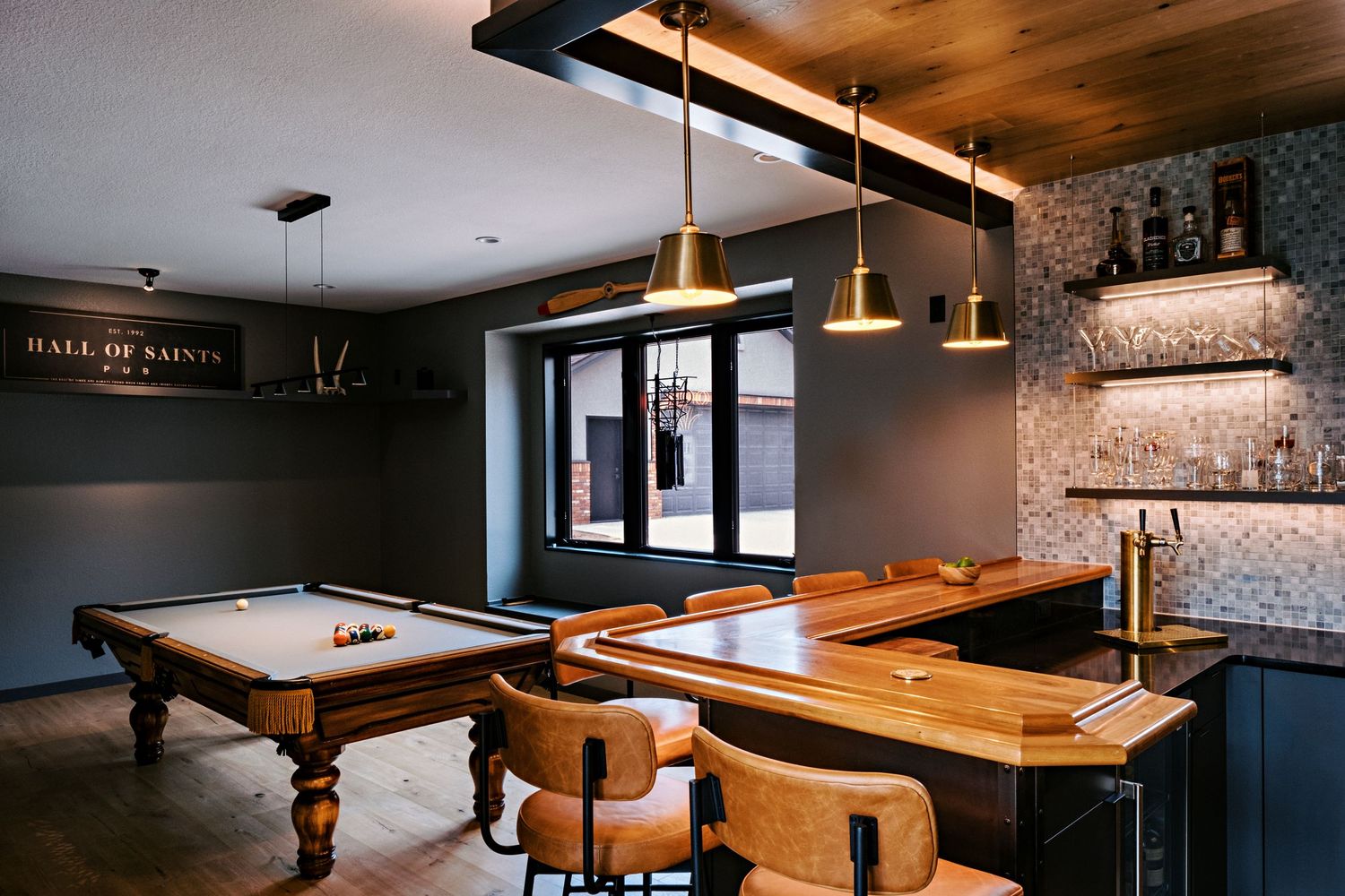 Upscale bar area with wood paneling and pendant lighting creating an intimate atmosphere.