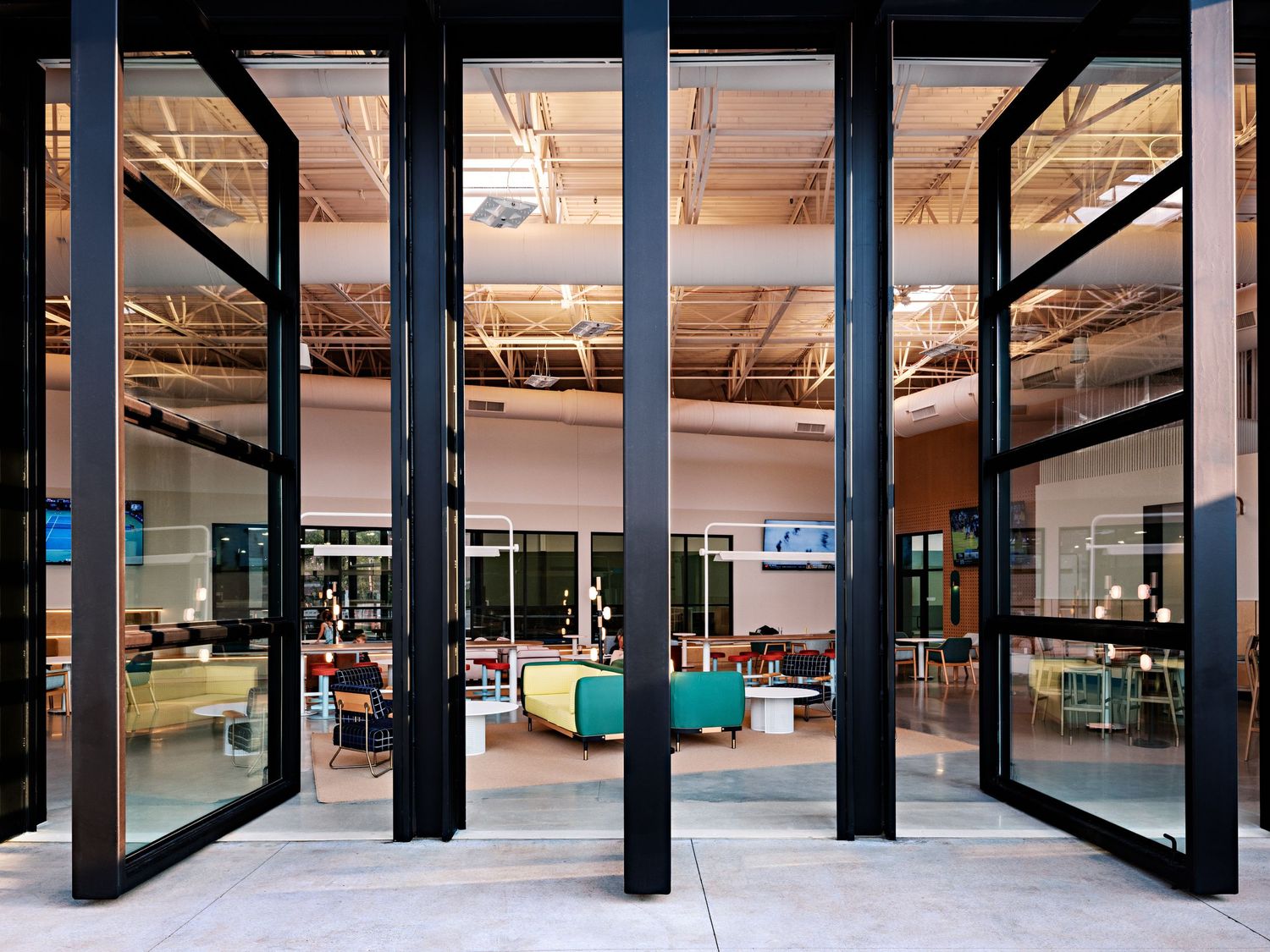 Industrial-style interior with large glass panels and black structural columns.