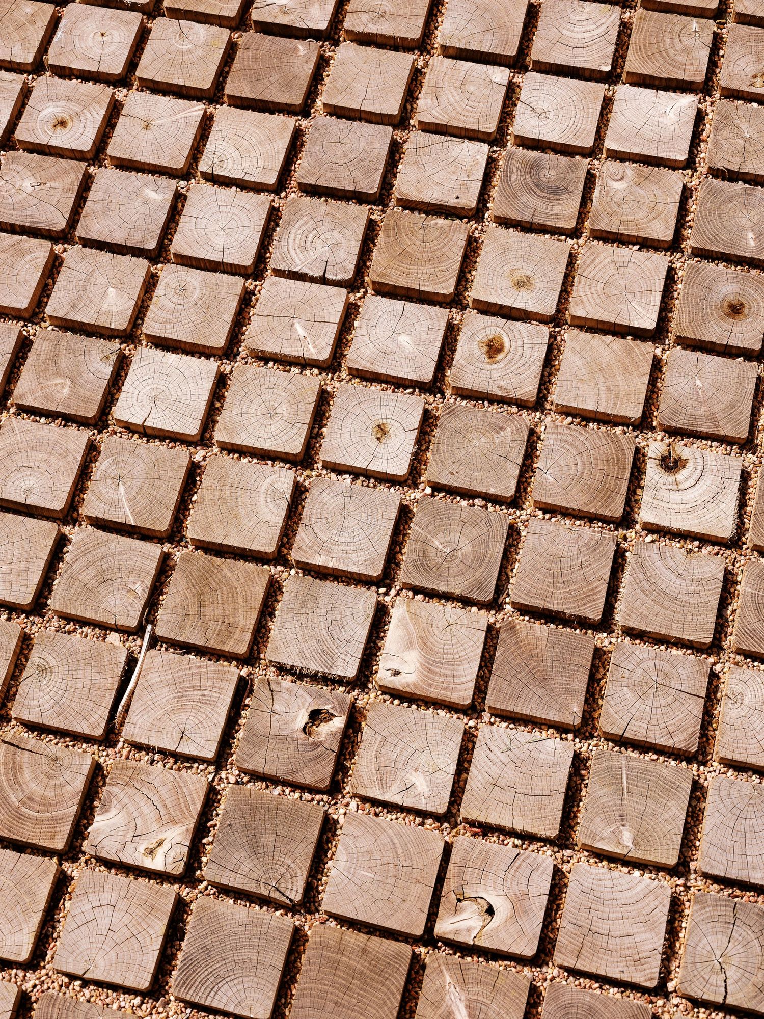 Close-up view of beige square tile pattern creating geometric texture on floor or wall surface.