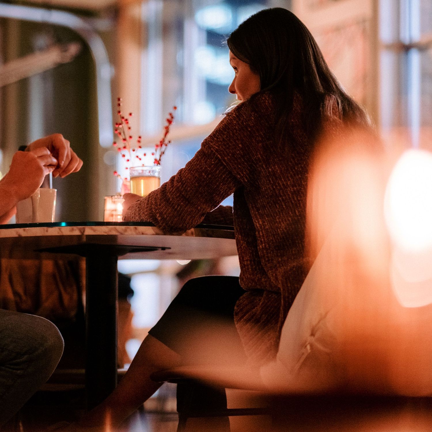 Warm candlelit table setting in a dimly lit restaurant creating an intimate ambiance.